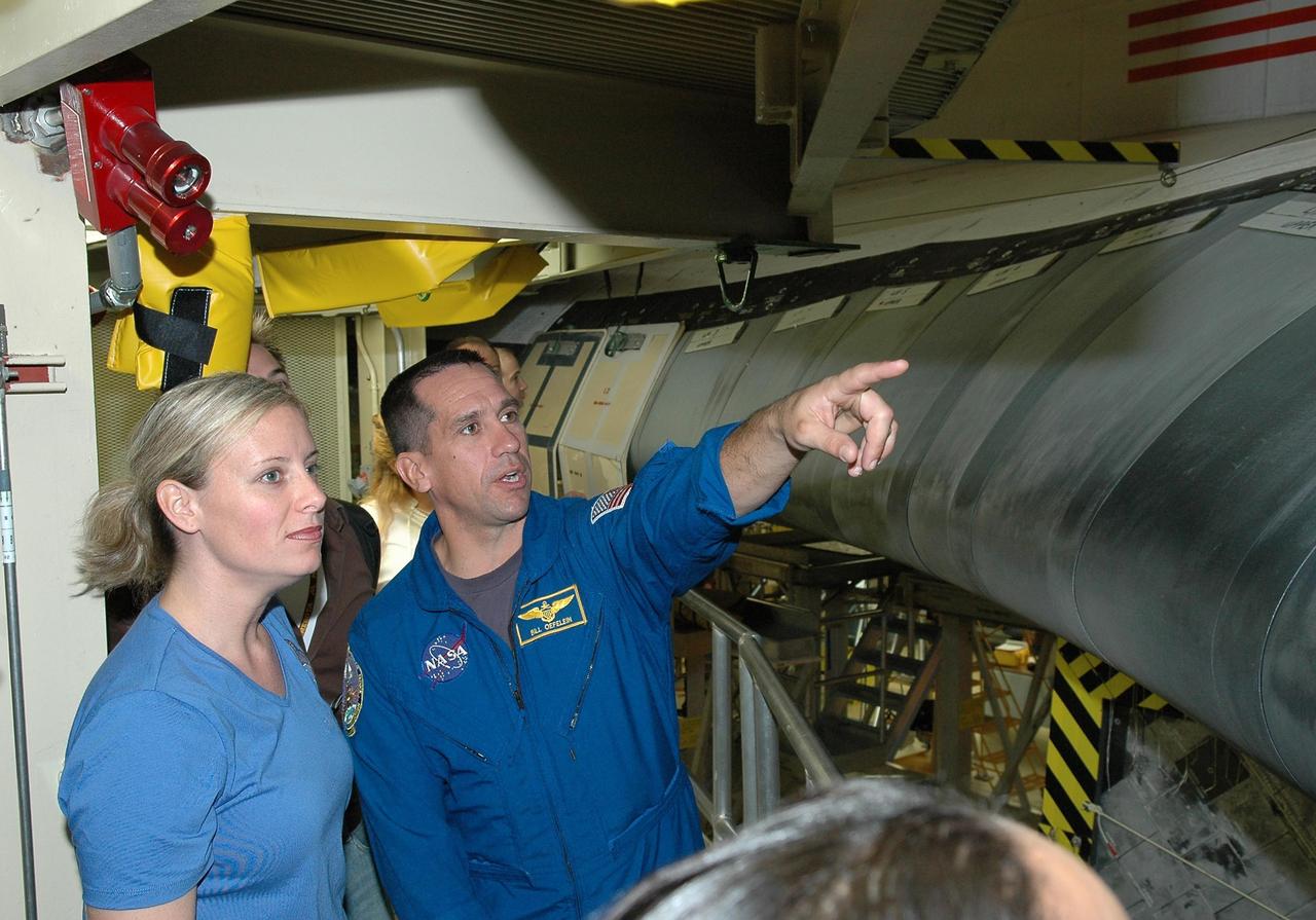 KENNEDY SPACE CENTER, FLA. - From a platform in the Orbiter Processing Facility, STS-116 Pilot William Oefelein points to Discovery’s reinforced carbon-carbon wing leading edge. He and other crew members are at KSC for a Crew Equipment Interface Test. Mission crews make frequent trips to the Kennedy Space Center to become familiar with the equipment and payloads they will be using. STS-116 will be mission No. 20 to the International Space Station and construction flight 12A.1. The mission payload is the SPACEHAB module, the P5 integrated truss structure and other key components. Launch is scheduled for no earlier than Dec. 7. Photo credit: NASA/Kim Shiflett
