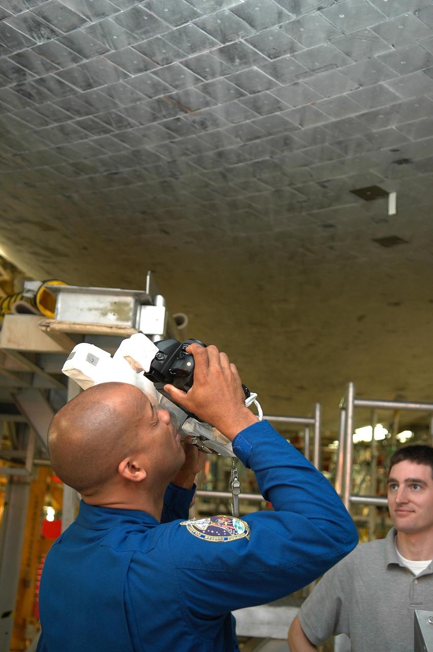 KENNEDY SPACE CENTER, FLA. - In the Orbiter Processing Facility, STS-116 Mission Specialist Robert Curbeam practices photographing the orbiter Discovery with a camera similar to those the crew will use on the mission. The crew is at KSC for a Crew Equipment Interface Test Mission crews make frequent trips to the Kennedy Space Center to become familiar with the equipment and payloads they will be using. STS-116 will be mission No. 20 to the International Space Station and construction flight 12A.1. The mission payload is the SPACEHAB module, the P5 integrated truss structure and other key components. Launch is scheduled for no earlier than Dec. 7. Photo credit: NASA/Kim Shiflett
