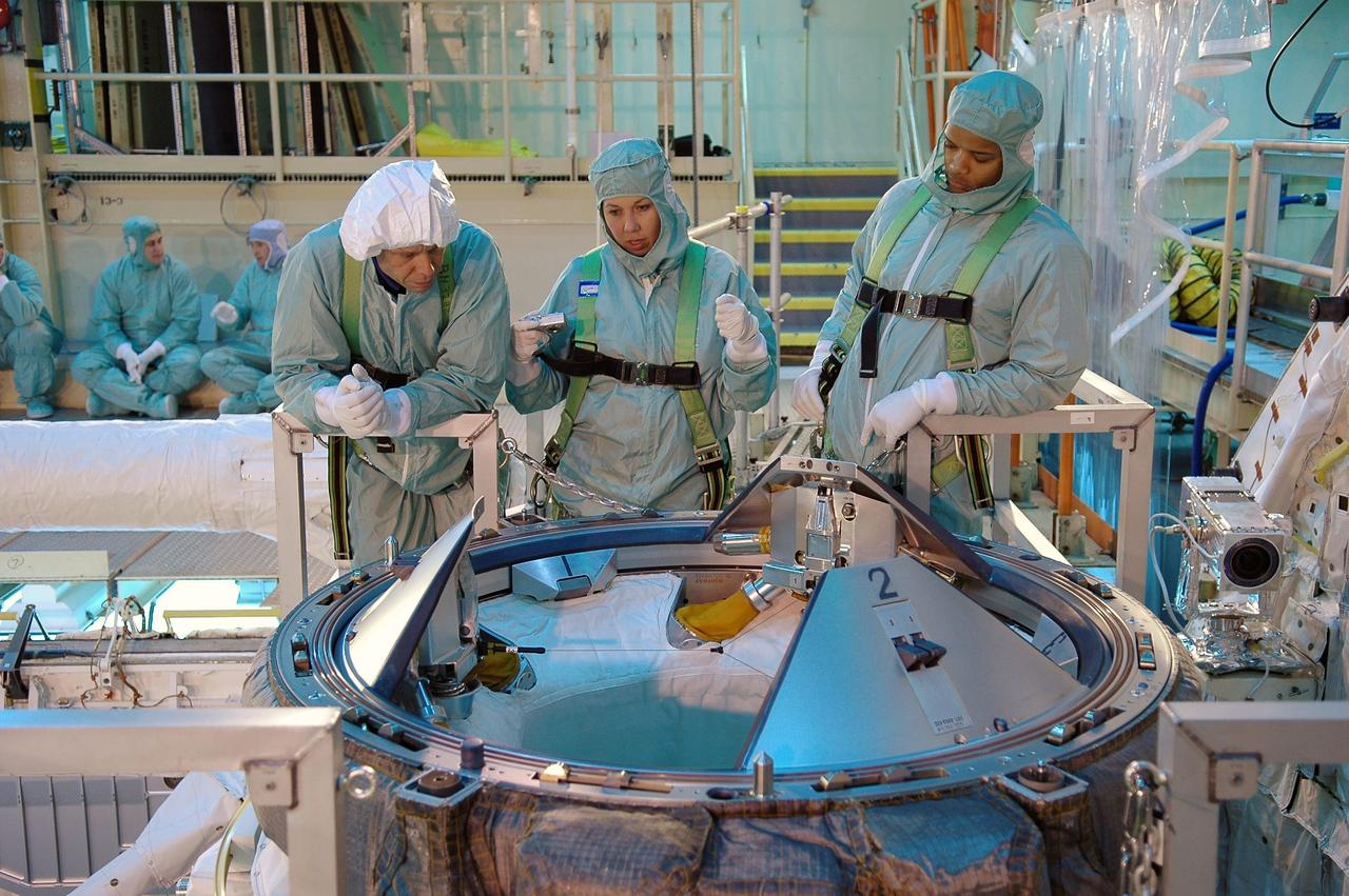 KENNEDY SPACE CENTER, FLA. -   During a Crew Equipment Interface Test (CEIT) in the Orbiter Processing Facility, STS-116 crew members get information about the external air lock they are looking at.  At left is Mission Specialist Christer Fugelsang and at right is Mission Specialist Robert Curbeam.  Fugelsang represents the European Space Agency.  A CEIT allows astronauts to become familiar with equipment and hardware they will use on the mission.  STS-116 will be mission No. 20 to the International Space Station and construction flight 12A.1.  The mission payload is the SPACEHAB module, the P5 integrated truss structure and other key components.   Launch is scheduled for no earlier than Dec. 7. Photo credit: NASA/Kim Shiflett