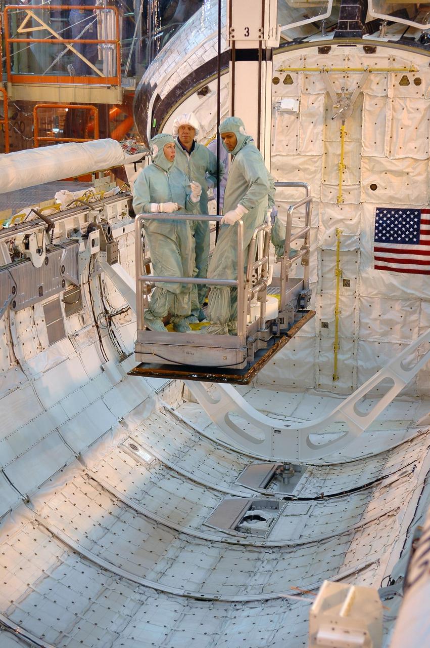 KENNEDY SPACE CENTER, FLA. -   During a Crew Equipment Interface Test (CEIT) in the Orbiter Processing Facility, STS-116 crew members are lowered into Discovery’s payload bay for a closer look.  In the white cap is Mission Specialist Christer Fugelsang; at right is Mission Specialist Robert Curbeam. Fugelsang represents the European Space Agency.  A CEIT allows astronauts to become familiar with equipment and hardware they will use on the mission.  STS-116 will be mission No. 20 to the International Space Station and construction flight 12A.1.  The mission payload is the SPACEHAB module, the P5 integrated truss structure and other key components.   Launch is scheduled for no earlier than Dec. 7. Photo credit: NASA/Kim Shiflett