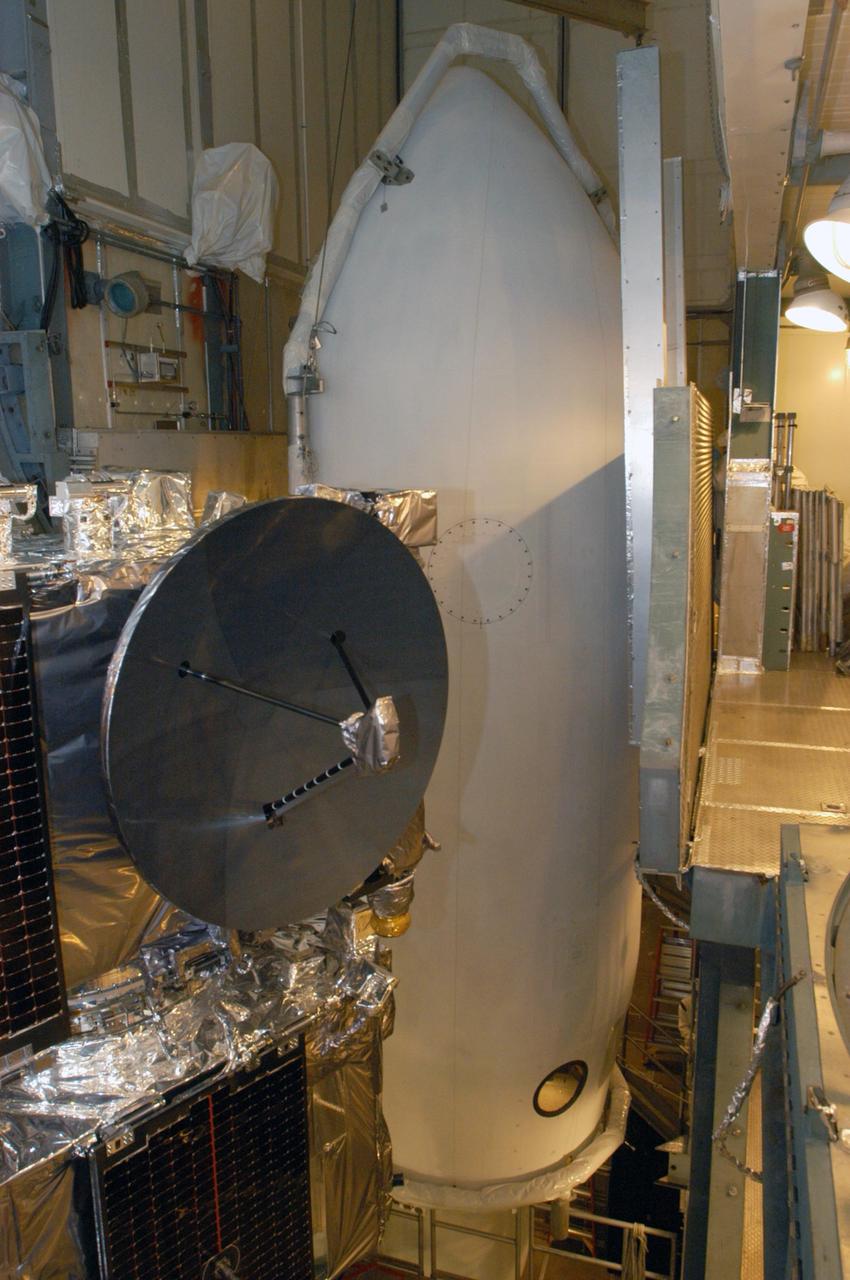 KENNEDY SPACE CENTER, FLA. -  Inside the mobile service tower on Launch Pad 17-B at Cape Canaveral Air Force Station, one segment of the fairing is lifted toward the STEREO spacecraft in the foreground.   The fairing is a molded structure that fits flush with the outside surface of the Delta II upper stage booster and forms an aerodynamically smooth nose cone, protecting the spacecraft during launch and ascent. The STEREO (Solar Terrestrial Relations Observatory) mission is the first to take measurements of the sun and solar wind in 3-dimension. This new view will improve our understanding of space weather and its impact on the Earth.  Designed and built by the Applied Physics Laboratory (APL) , the STEREO mission is being managed by NASA Goddard Space Flight Center. APL will maintain command and control of the observatories throughout the mission, while NASA tracks and receives the data, determines the orbit of the satellites, and coordinates the science results. STEREO is expected to lift off Oct. 25. Photo credit: NASA/George Shelton