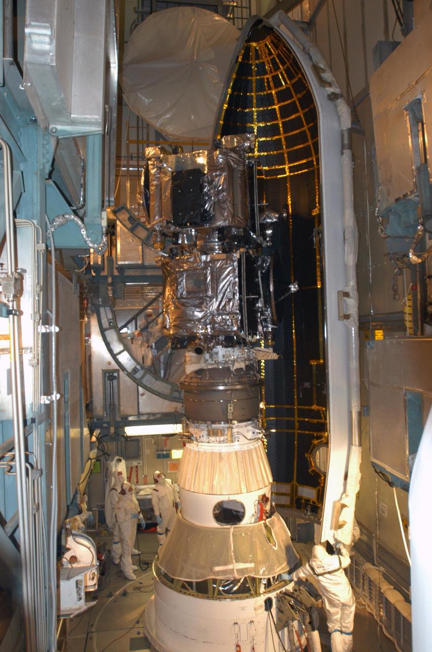 KENNEDY SPACE CENTER, FLA. -   Inside the mobile service tower on Launch Pad 17-B at Cape Canaveral Air Force Station, workers help maneuver one segment of the fairing around the STEREO spacecraft.   The fairing is a molded structure that fits flush with the outside surface of the Delta II upper stage booster and forms an aerodynamically smooth nose cone, protecting the spacecraft during launch and ascent. The STEREO (Solar Terrestrial Relations Observatory) mission is the first to take measurements of the sun and solar wind in 3-dimension. This new view will improve our understanding of space weather and its impact on the Earth.  Designed and built by the Applied Physics Laboratory (APL) , the STEREO mission is being managed by NASA Goddard Space Flight Center. APL will maintain command and control of the observatories throughout the mission, while NASA tracks and receives the data, determines the orbit of the satellites, and coordinates the science results. STEREO is expected to lift off Oct. 25. Photo credit: NASA/George Shelton