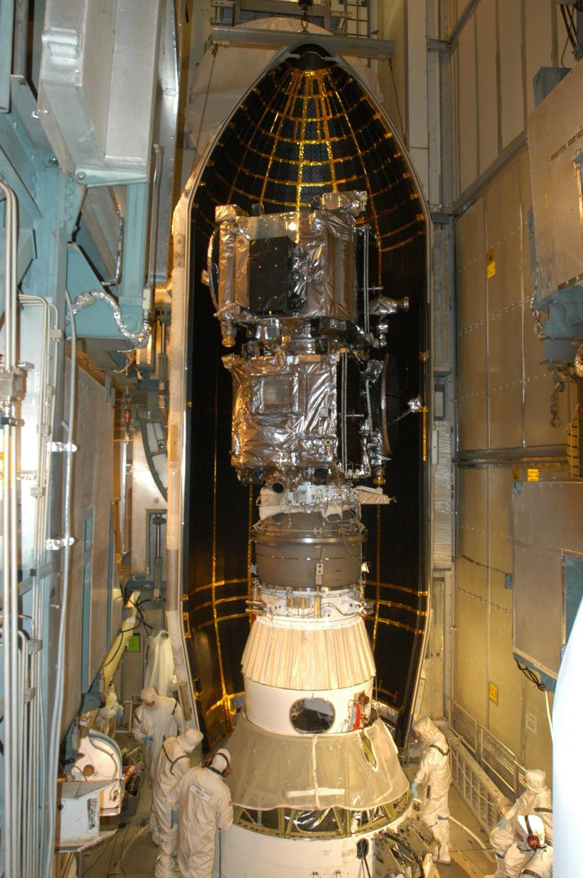 KENNEDY SPACE CENTER, FLA. -   Inside the mobile service tower on Launch Pad 17-B at Cape Canaveral Air Force Station, workers check the placement of the first half of the fairing around the STEREO spacecraft.   The fairing is a molded structure that fits flush with the outside surface of the Delta II upper stage booster and forms an aerodynamically smooth nose cone, protecting the spacecraft during launch and ascent. The STEREO (Solar Terrestrial Relations Observatory) mission is the first to take measurements of the sun and solar wind in 3-dimension. This new view will improve our understanding of space weather and its impact on the Earth.  Designed and built by the Applied Physics Laboratory (APL) , the STEREO mission is being managed by NASA Goddard Space Flight Center. APL will maintain command and control of the observatories throughout the mission, while NASA tracks and receives the data, determines the orbit of the satellites, and coordinates the science results. STEREO is expected to lift off Oct. 25. Photo credit: NASA/George Shelton
