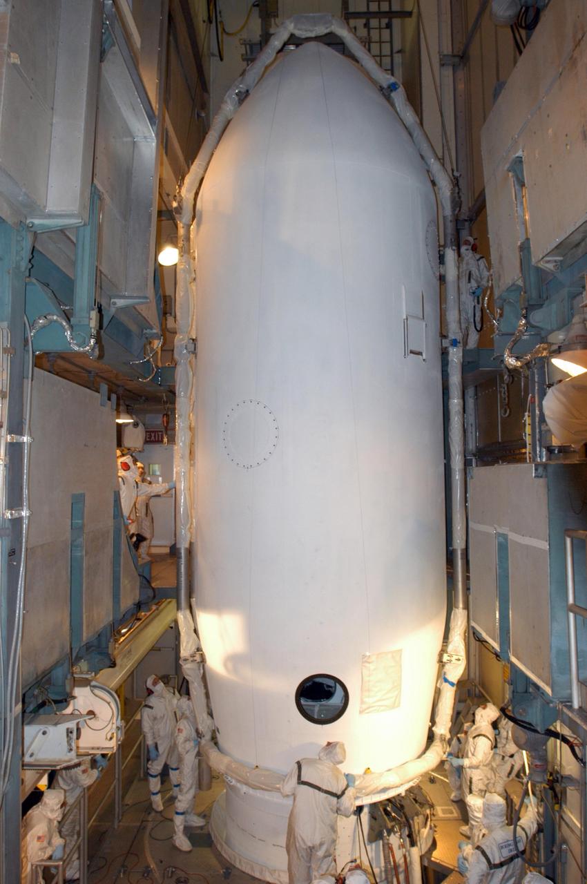 KENNEDY SPACE CENTER, FLA. -  Inside the mobile service tower on Launch Pad 17-B at Cape Canaveral Air Force Station, workers maneuver the second half of the fairing into place around the STEREO spacecraft.  The fairing is a molded structure that fits flush with the outside surface of the Delta II upper stage booster and forms an aerodynamically smooth nose cone, protecting the spacecraft during launch and ascent. The STEREO (Solar Terrestrial Relations Observatory) mission is the first to take measurements of the sun and solar wind in 3-dimension. This new view will improve our understanding of space weather and its impact on the Earth.  Designed and built by the Applied Physics Laboratory (APL) , the STEREO mission is being managed by NASA Goddard Space Flight Center. APL will maintain command and control of the observatories throughout the mission, while NASA tracks and receives the data, determines the orbit of the satellites, and coordinates the science results. STEREO is expected to lift off Oct. 25. Photo credit: NASA/George Shelton