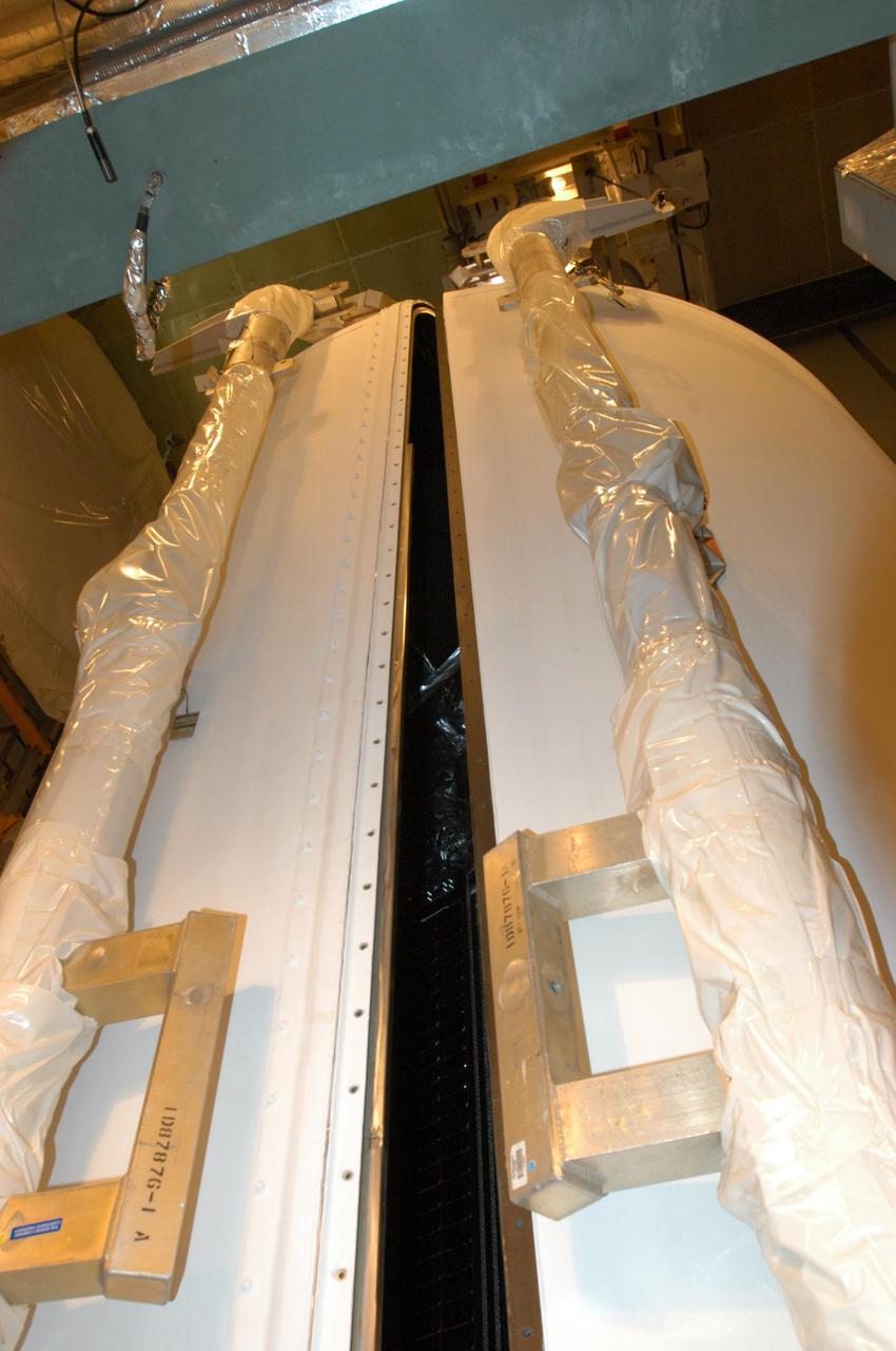 KENNEDY SPACE CENTER, FLA. -   Inside the mobile service tower on Launch Pad 17-B at Cape Canaveral Air Force Station, the two fairing segments close in around the STEREO spacecraft. The fairing is a molded structure that fits flush with the outside surface of the Delta II upper stage booster and forms an aerodynamically smooth nose cone, protecting the spacecraft during launch and ascent. The STEREO (Solar Terrestrial Relations Observatory) mission is the first to take measurements of the sun and solar wind in 3-dimension. This new view will improve our understanding of space weather and its impact on the Earth.  Designed and built by the Applied Physics Laboratory (APL) , the STEREO mission is being managed by NASA Goddard Space Flight Center. APL will maintain command and control of the observatories throughout the mission, while NASA tracks and receives the data, determines the orbit of the satellites, and coordinates the science results. STEREO is expected to lift off Oct. 25. Photo credit: NASA/George Shelton