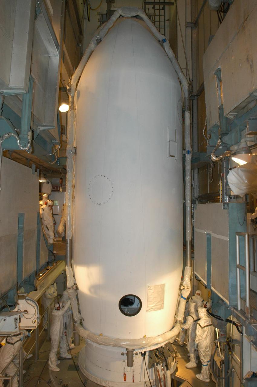 KENNEDY SPACE CENTER, FLA. -   Inside the mobile service tower on Launch Pad 17-B at Cape Canaveral Air Force Station, workers secure the two halves of the fairing that enclose the STEREO spacecraft.  The fairing is a molded structure that fits flush with the outside surface of the Delta II upper stage booster and forms an aerodynamically smooth nose cone, protecting the spacecraft during launch and ascent. The STEREO (Solar Terrestrial Relations Observatory) mission is the first to take measurements of the sun and solar wind in 3-dimension. This new view will improve our understanding of space weather and its impact on the Earth.  Designed and built by the Applied Physics Laboratory (APL) , the STEREO mission is being managed by NASA Goddard Space Flight Center. APL will maintain command and control of the observatories throughout the mission, while NASA tracks and receives the data, determines the orbit of the satellites, and coordinates the science results. STEREO is expected to lift off Oct. 25. Photo credit: NASA/George Shelton