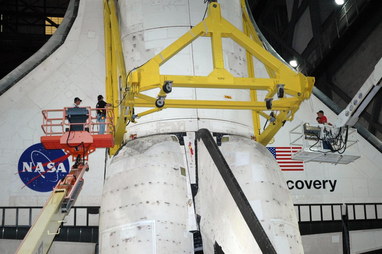 KENNEDY SPACE CENTER, FLA. --  Workers in the Vehicle Assembly Building detach part of the crane used to raise Discovery from its transporter.  Still attached to the sling, Discovery will be lifted up into high bay 3 and lowered onto the mobile launcher platform where the external tank and solid rocket boosters are already stacked. Space Shuttle Discovery is scheduled to roll out to Launch Pad 39B no earlier than Nov. 7 for mission STS-116.  The mission is No. 20 to the International Space Station and construction flight 12A.1. The mission payload is the SPACEHAB module, the P5 integrated truss structure and other key components. The launch window for mission STS-116 opens Dec. 7.  Photo credit: NASA/Jack Pfaller