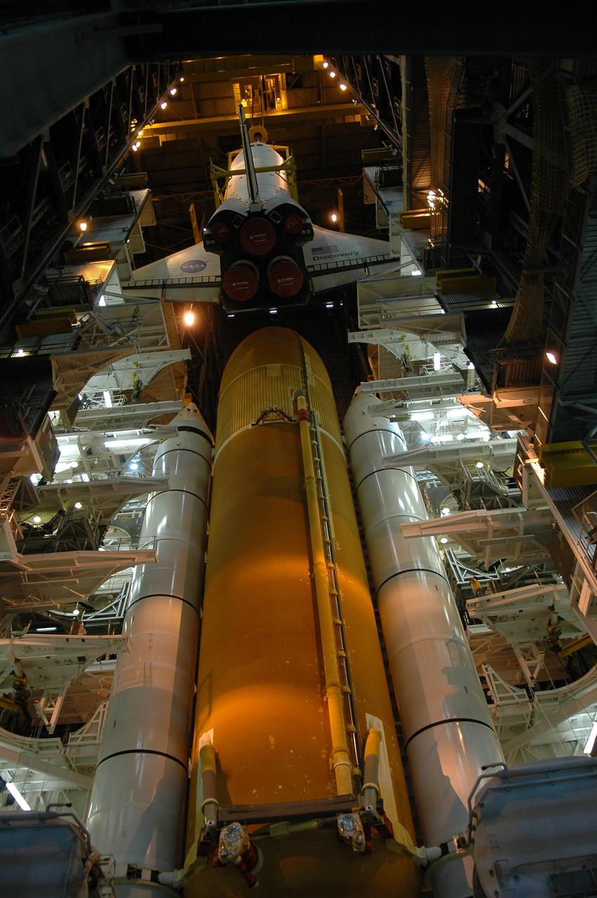 KENNEDY SPACE CENTER, FLA. --  In high bay 3 of the Vehicle Assembly Building, the orbiter Discovery is being lowered toward the external tank and solid rocket boosters installed on the mobile launcher platform.  The orbiter will be stacked with the tank and SRBs for launch.  Space Shuttle Discovery is scheduled to roll out to Launch Pad 39B no earlier than Nov. 7 for mission STS-116.  The mission is No. 20 to the International Space Station and construction flight 12A.1. The mission payload is the SPACEHAB module, the P5 integrated truss structure and other key components. The launch window for mission STS-116 opens Dec. 7. Photo credit: NASA/Kim Shiflett