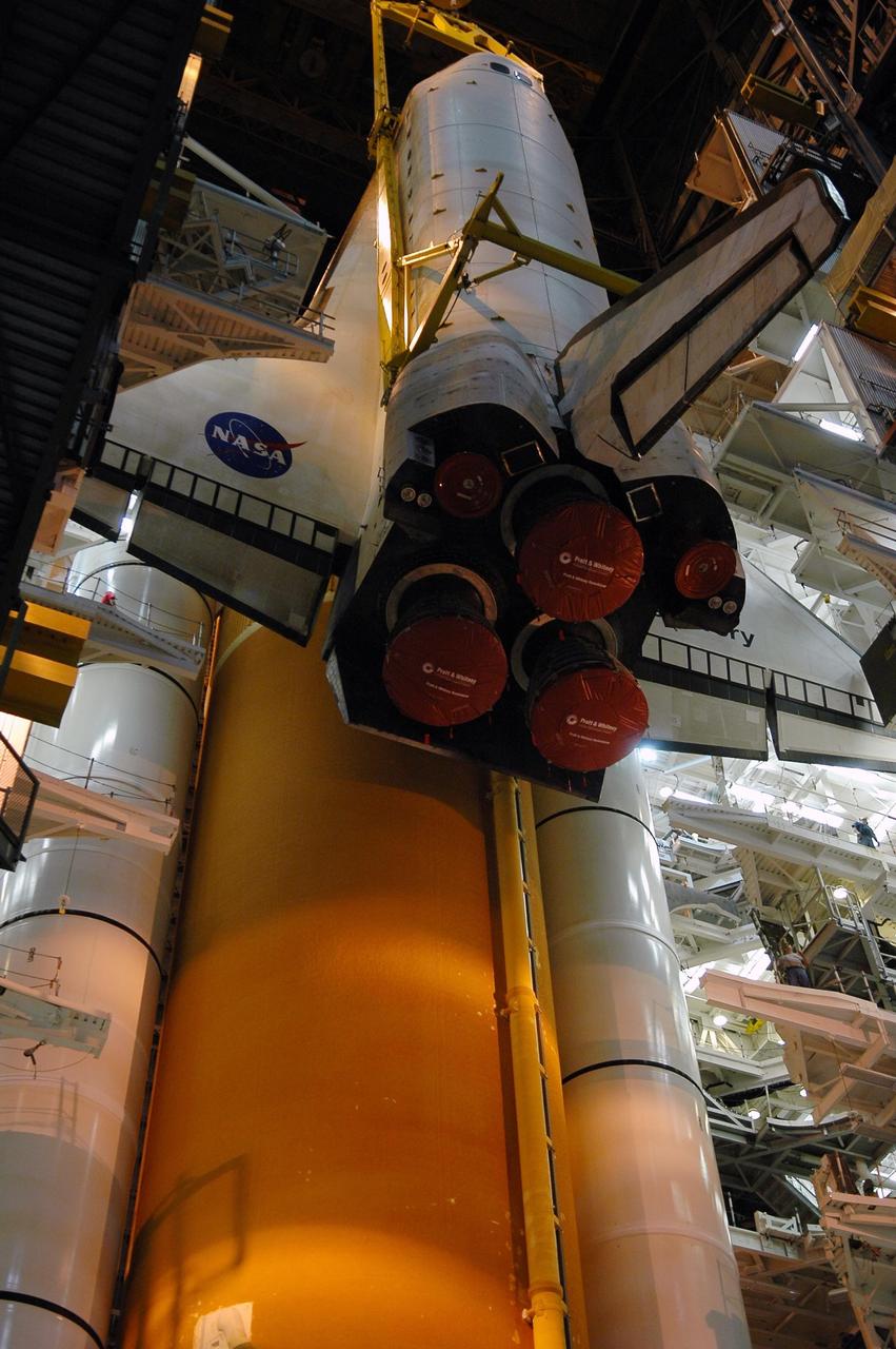 KENNEDY SPACE CENTER, FLA. -- The orbiter Discovery is lowered toward the mobile launcher platform in high bay 3 of the Vehicle Assembly Building.  Behind the vehicle are the external tank and solid rocket boosters already stacked on the MLP.  Discovery will be mated to the stack in preparation for launch.  Space Shuttle Discovery is scheduled to roll out to Launch Pad 39B no earlier than Nov. 7 for mission STS-116.  The mission is No. 20 to the International Space Station and construction flight 12A.1. The mission payload is the SPACEHAB module, the P5 integrated truss structure and other key components. The launch window for mission STS-116 opens Dec. 7. Photo credit: NASA/Kim Shiflett