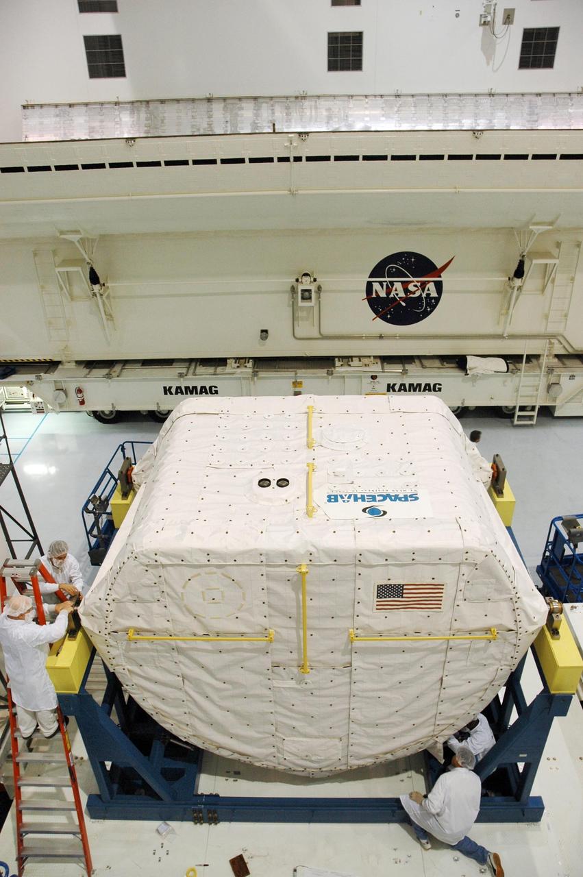 KENNEDY SPACE CENTER, FLA. --  Inside the Space Station Processing Facility, technicians secure the protective coverings on the SPACEHAB Module before it is transferred to the Payload Canister. The SPACEHAB Module will carry racks of experiments, flight hardware, spacewalk equipment and supplies to support mission STS-116 to the International Space Station. STS-116 will be mission number 20 to the station and construction flight 12A.1.  Along with SPACEHAB, the mission payload on Space Shuttle Discovery includes the P5 integrated truss structure and other key components. The launch window opens Dec. 7.  Photo credit: NASA/Troy Cryder