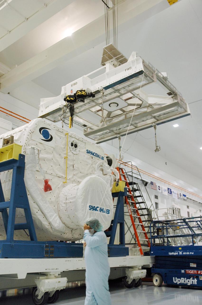KENNEDY SPACE CENTER, FLA. --  Inside the Space Station Processing Facility, an overhead crane moves towards the SPACEHAB Module to transport in to the Payload Canister. The SPACEHAB Module will carry racks of experiments, flight hardware, spacewalk equipment and supplies to support mission STS-116 to the International Space Station. STS-116 will be mission number 20 to the station and construction flight 12A.1. Along with SPACEHAB, the mission payload on Space Shuttle Discovery includes the P5 integrated truss structure and other key components. The launch window opens Dec. 7.  Photo credit: NASA/Troy Cryder