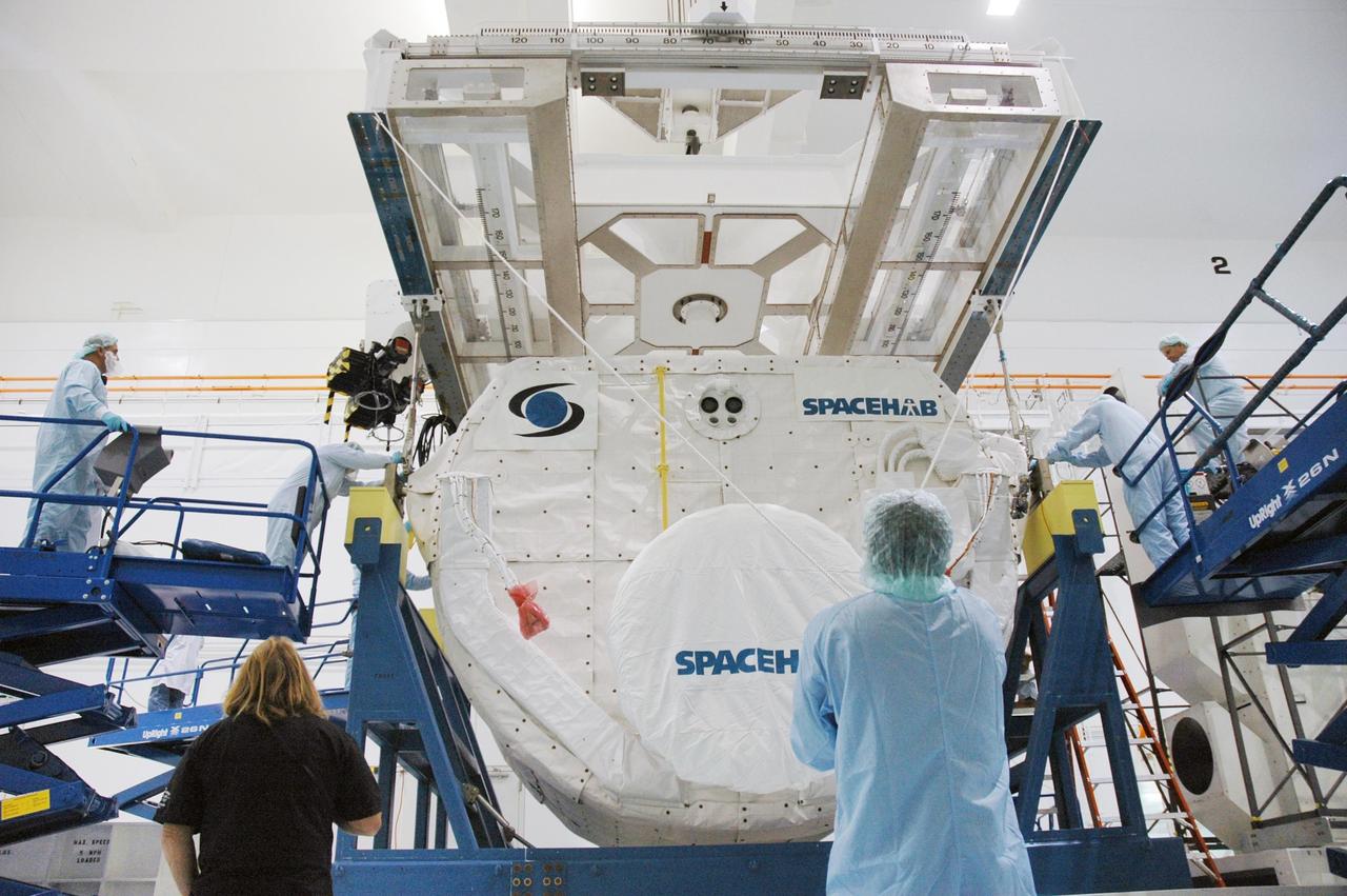 KENNEDY SPACE CENTER, FLA. --  Inside the Space Station Processing Facility, technicians secure the SPACEHAB Module to the overhead crane for transfer to the Payload Canister. The SPACEHAB Module will carry racks of experiments, flight hardware, spacewalk equipment and supplies to support mission STS-116 to the International Space Station.  STS-116 will be mission number 20 to the station and construction flight 12A.1. Along with SPACEHAB, the mission payload on Space Shuttle Discovery includes the P5 integrated truss structure and other key components. The launch window opens Dec. 7.  Photo credit: NASA/Troy Cryder