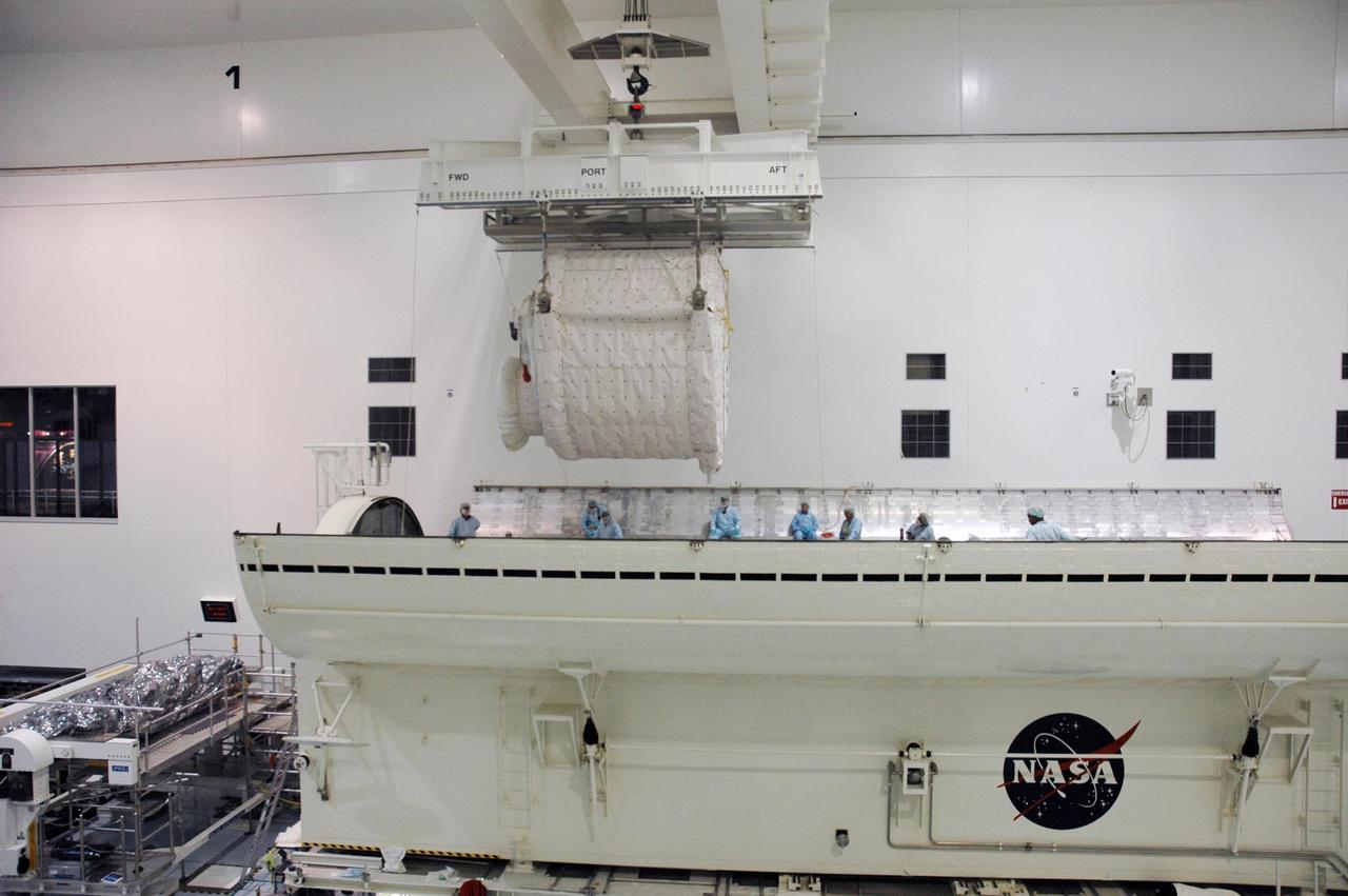 KENNEDY SPACE CENTER, FLA. --    Inside the Space Station Processing Facility, an overhead crane lowers the SPACEHAB Module into the Payload Canister. The SPACEHAB Module will carry racks of experiments, flight hardware, spacewalk equipment and supplies to support mission STS-116 to the International Space Station.  STS-116 will be mission number 20 to the station and construction flight 12A.1. Along with SPACEHAB, the mission payload on Space Shuttle Discovery includes the P5 integrated truss structure and other key components. The launch window opens Dec. 7.  Photo credit: NASA/Troy Cryder