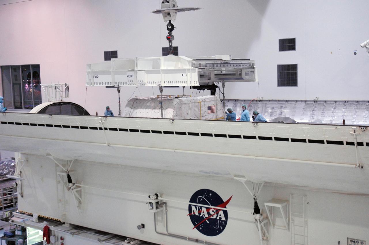 KENNEDY SPACE CENTER, FLA. --     Inside the Space Station Processing Facility, an overhead crane lowers the SPACEHAB Module into the Payload Canister. The SPACEHAB Module will carry racks of experiments, flight hardware, spacewalk equipment and supplies to support mission STS-116 to the International Space Station.  STS-116 will be mission number 20 to the station and construction flight 12A.1. Along with SPACEHAB, the mission payload on Space Shuttle Discovery includes the P5 integrated truss structure and other key components. The launch window opens Dec. 7.  Photo credit: NASA/Troy Cryder