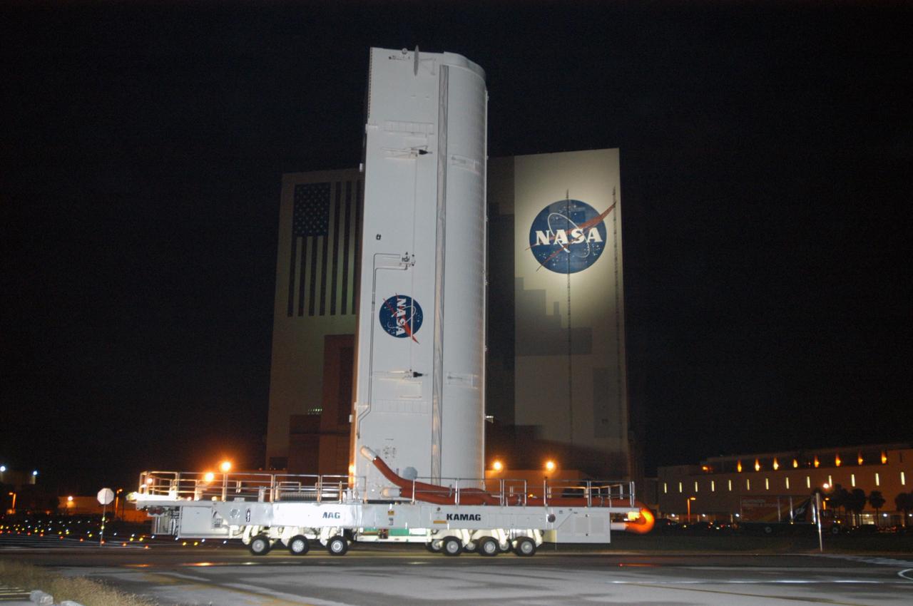 KENNEDY SPACE CENTER, FLA. --   Lamps spotlight the payload canister transporter as it slowly carries its cargo past the Vehicle Assembly Building on the road to Launch Pad 39B for mission STS-116.  Inside the canister are the SPACEHAB module and the port 5 truss segment, which will be moved into the payload changeout room at the pad and transferred into Space Shuttle Discovery's payload bay once the vehicle has rolled out to the pad. The payload canister is 65 feet long, 18 feet wide and 18 feet, 7 inches high. It has the capability to carry vertically or horizontally processed payloads up to 15 feet in diameter and 60 feet long, matching the capacity of the orbiter payload bay. It can carry payloads weighing up to 65,000 pounds. Clamshell-shaped doors at the top of the canister operate like the orbiter payload bay doors, with the same allowable clearances. Photo credit: NASA/George Shelton