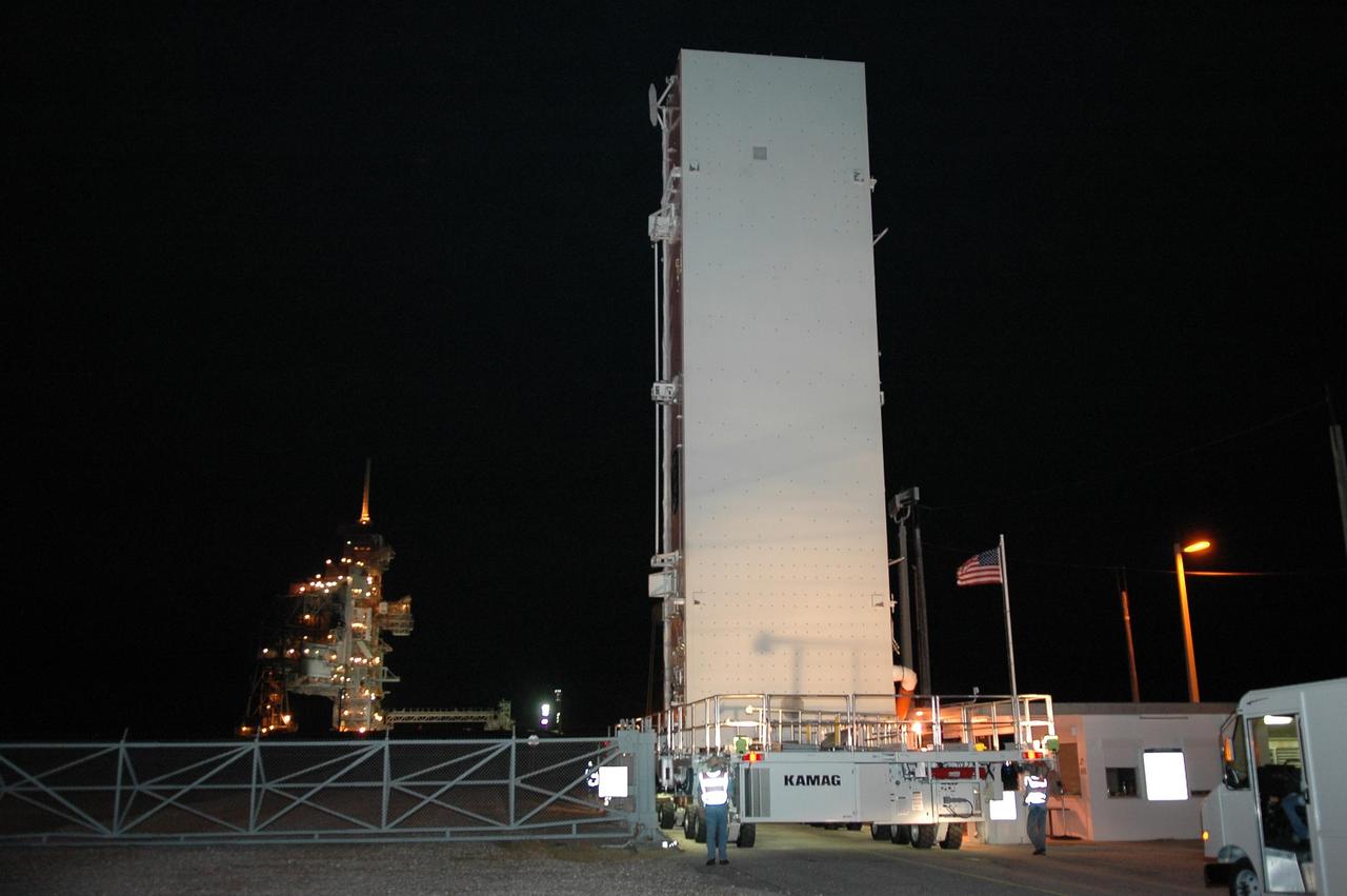 KENNEDY SPACE CENTER, FLA. --   The payload canister transporter and canister arrive at the gate to Launch Pad 39B.  Inside the canister are the SPACEHAB module and the port 5 truss segment for mission STS-116.  They will be moved into the payload changeout room (PCR) at the pad and transferred into Space Shuttle Discovery's payload bay once the vehicle has rolled out to the pad.  The PCR is the enclosed, environmentally controlled portion of the RSS that supports cargo delivery to the pad and subsequent vertical installation into the orbiter payload bay. Seals around the mating surface of the PCR fit against the orbiter and allow the opening of the payload bay or canister doors and removal of the cargo without exposure to outside air and contaminants. A clean-air purge in the PCR maintains environmental control during PCR cargo operations. Cargo is removed from the payload canister and installed vertically in the orbiter by the payload ground handling mechanism (PGHM). Photo credit: NASA/Kim Shiflett