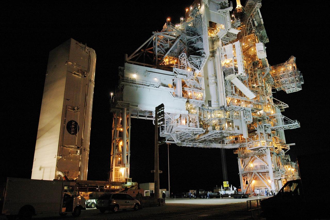 KENNEDY SPACE CENTER, FLA. -- The payload canister transporter and canister approach the rotating service structure (RSS) on Launch Pad 39B. Inside the canister are the SPACEHAB module and the port 5 truss segment for mission STS-116.  They will be moved into the payload changeout room (PCR) on the RSS and transferred into Space Shuttle Discovery's payload bay once the vehicle has rolled out to the pad. The PCR is the enclosed, environmentally controlled portion of the RSS that supports cargo delivery to the pad and subsequent vertical installation into the orbiter payload bay. Seals around the mating surface of the PCR fit against the orbiter and allow the opening of the payload bay or canister doors and removal of the cargo without exposure to outside air and contaminants. A clean-air purge in the PCR maintains environmental control during PCR cargo operations. Cargo is removed from the payload canister and installed vertically in the orbiter by the payload ground handling mechanism (PGHM). Photo credit: NASA/Kim Shiflett