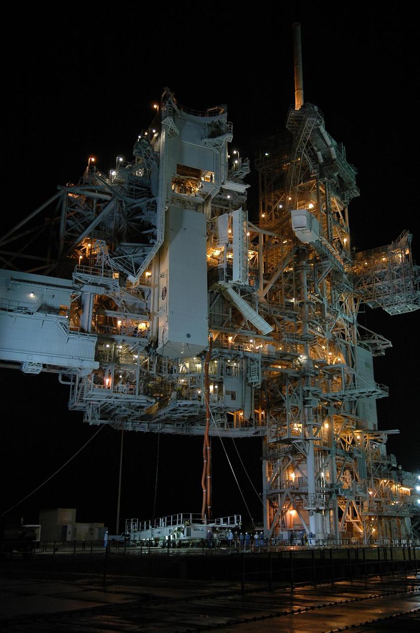 KENNEDY SPACE CENTER, FLA. --  With umbilical lines still attached, the payload canister is lifted up to the payload changeout room (PCR) on the rotating service structure (RSS) on Launch Pad 39B.  Inside the canister are the SPACEHAB module and the port 5 truss segment for mission STS-116.  Once inside the PCR, they will be transferred into Space Shuttle Discovery's payload bay once the vehicle has rolled out to the pad. On the right is the fixed service structure. The PCR is the enclosed, environmentally controlled portion of the RSS that supports cargo delivery to the pad and subsequent vertical installation into the orbiter payload bay. Seals around the mating surface of the PCR fit against the orbiter and allow the opening of the payload bay or canister doors and removal of the cargo without exposure to outside air and contaminants. A clean-air purge in the PCR maintains environmental control during PCR cargo operations. Cargo is removed from the payload canister and installed vertically in the orbiter by the payload ground handling mechanism (PGHM). Photo credit: NASA/Kim Shiflett
