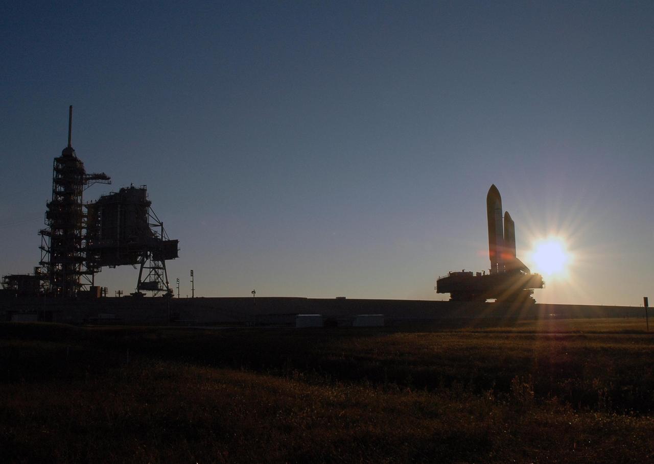 KENNEDY SPACE CENTER, FLA. --  Silhouetted by the rising sun behind it, Space Shuttle Discovery, atop the mobile launcher platform and the crawler-transporter underneath, makes its final approach up the ramp to Launch Pad 39B for launch of mission STS-116. The mission is No. 20 to the International Space Station and construction flight 12A.1. The mission payload is the SPACEHAB module, the P5 integrated truss structure and other key components. The launch window for mission STS-116 opens Dec. 7. Photo credit: NASA/Amanda Diller