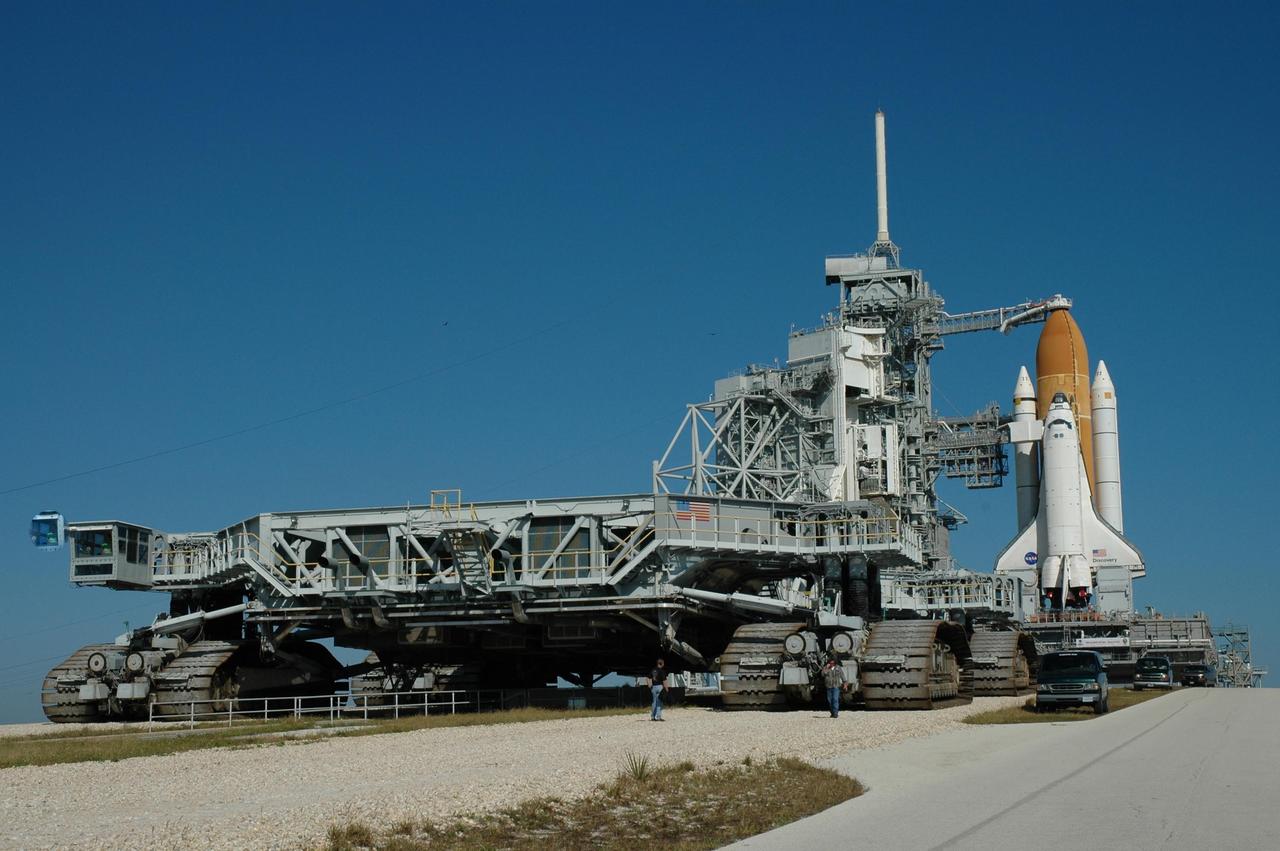 KENNEDY SPACE CENTER, FLA. -- The crawler-transporter moves away from Launch Pad 39B after depositing its cargo, Space Shuttle Discovery and the mobile launcher platform. The shuttle's external tank is capped by the oxygen vent hood. Farther to the left above the fixed service structure is the 80-foot tall lightning mast. The rollout from the Vehicle Assembly Building began at 12:29 a.m. The shuttle was harddown on the pad at 9:03 a.m. The mission is No. 20 to the International Space Station and construction flight 12A.1. The mission payload is the SPACEHAB module, the P5 integrated truss structure and other key components. The launch window for mission STS-116 opens Dec. 7. Photo credit: NASA/Jim Grossmann