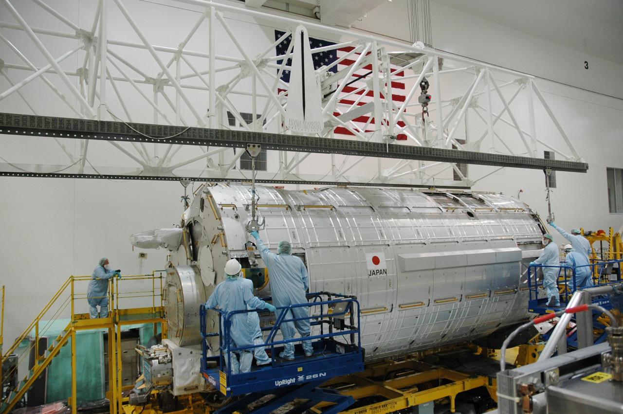 KENNEDY SPACE CENTER, FLA. -- In the Space Station Processing Facility, workers are attaching an overhead crane to the Japanese Experiment Module (JEM) in order to  lift it.  The module is being moved to a stand where it will be weighed and measured for its center of gravity. The Japanese Aerospace Exploration Agency developed the laboratory at the Tsukuba Space Center near Tokyo. It is the first element, named "Kibo" (Hope), to be delivered to KSC. The JEM is Japan's primary contribution to the International Space Station. It will enhance the unique research capabilities of the orbiting complex by providing an additional environment for astronauts to conduct science experiments. The JEM is targeted for mission STS-124, to launch in early 2008.  Photo credit: NASA/Troy Cryder