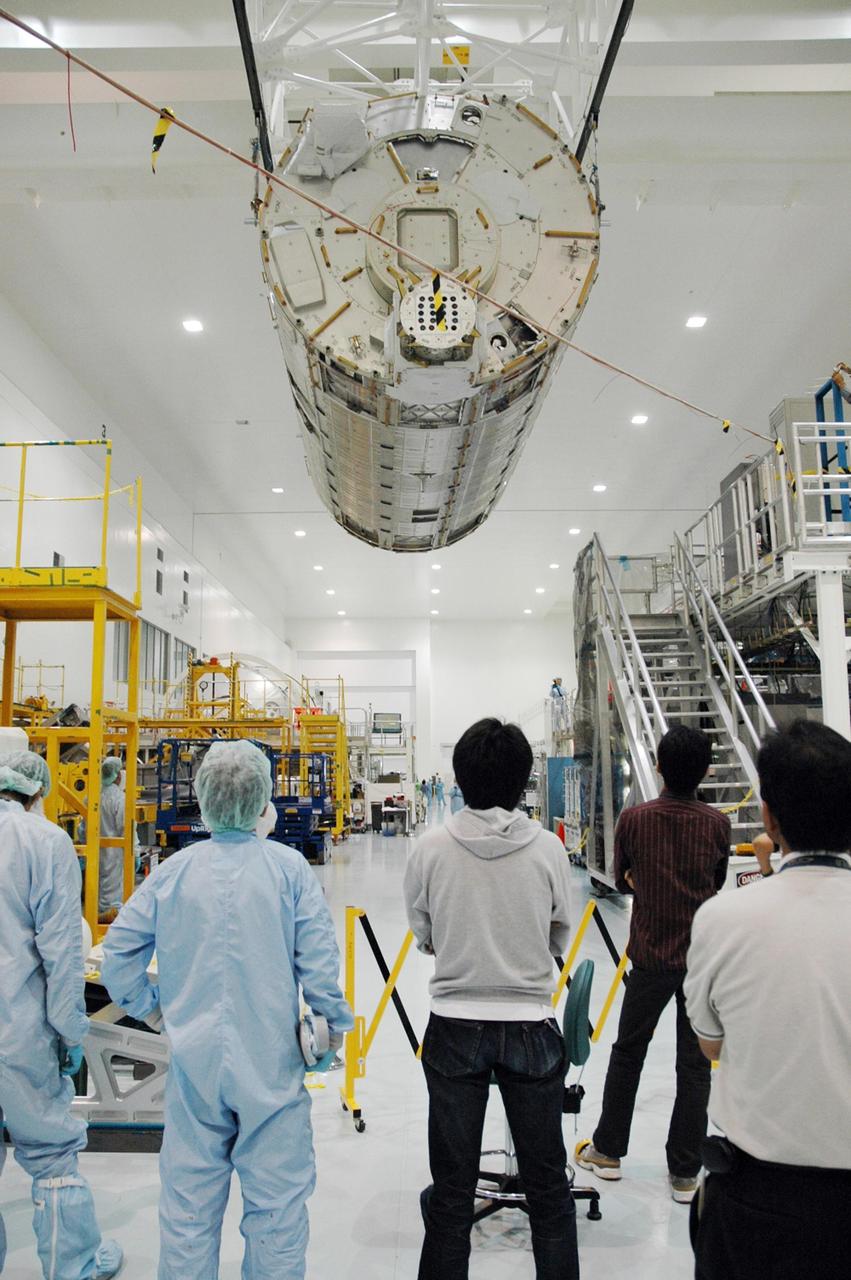 KENNEDY SPACE CENTER, FLA. --   In the Space Station Processing Facility, workers on the floor watch as an overhead crane moves the Japanese Experiment Module (JEM) to a stand for weighing. The Japanese Aerospace Exploration Agency developed the laboratory at the Tsukuba Space Center near Tokyo. It is the first element, named "Kibo" (Hope), to be delivered to KSC. The JEM is Japan's primary contribution to the International Space Station. It will enhance the unique research capabilities of the orbiting complex by providing an additional environment for astronauts to conduct science experiments. The JEM is targeted for mission STS-124, to launch in early 2008.  Photo credit: NASA/Troy Cryder