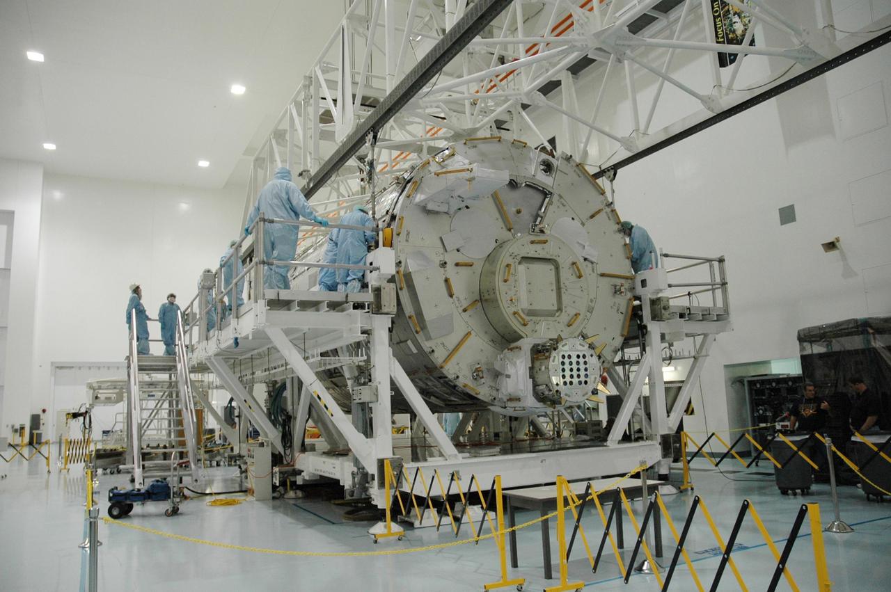 KENNEDY SPACE CENTER, FLA. --  In the Space Station Processing Facility, workers monitor the movement of the Japanese Experiment Module (JEM) as it is lowered onto a weighing stand.  The module will also be measured for its center of gravity. The Japanese Aerospace Exploration Agency developed the laboratory at the Tsukuba Space Center near Tokyo. It is the first element, named "Kibo" (Hope), to be delivered to KSC. The JEM is Japan's primary contribution to the International Space Station. It will enhance the unique research capabilities of the orbiting complex by providing an additional environment for astronauts to conduct science experiments. The JEM is targeted for mission STS-124, to launch in early 2008.  Photo credit: NASA/Troy Cryder