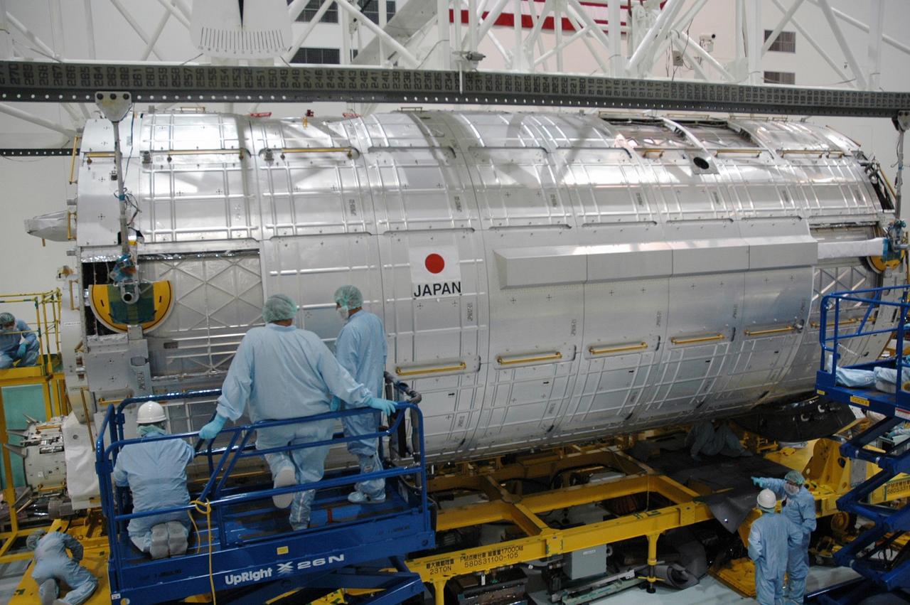 KENNEDY SPACE CENTER, FLA. -- In the Space Station Processing Facility, workers monitor the placement of the Japanese Experiment Module (JEM) onto its transporter.  The JEM was moved from the transporter for weighing and to measure its center of gravity.  The Japanese Aerospace Exploration Agency developed the laboratory at the Tsukuba Space Center near Tokyo. It is the first element, named "Kibo" (Hope), to be delivered to KSC. The JEM is Japan's primary contribution to the International Space Station. It will enhance the unique research capabilities of the orbiting complex by providing an additional environment for astronauts to conduct science experiments. The JEM is targeted for mission STS-124, to launch in early 2008.  Photo credit: NASA/Troy Cryder