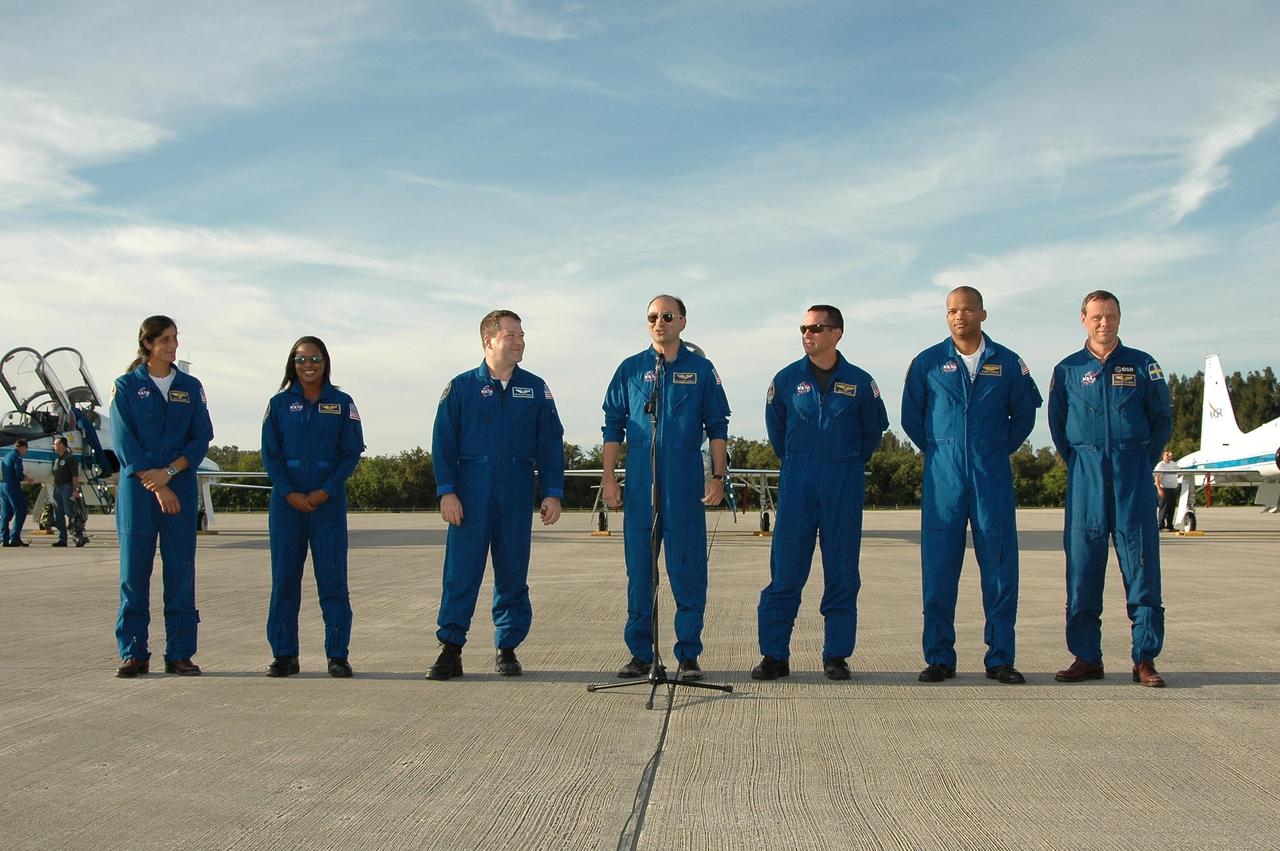 KENNEDY SPACE CENTER, FLA. -- The STS-116 crew pauses for the media at the Shuttle Landing Facility after their arrival. At the microphone is Mission Commander Mark Polansky. The crew members (from left) are Mission Specialists Sunita Williams, Joan Higginbotham and Nicholas Patrick, Polansky, Pilot William Oefelein, and Mission Specialists Robert Curbeam and Christer Fuglesang. The crew has returned to KSC for the terminal countdown demonstration test, which are prelaunch preparations that include a simulated launch countdown. The mission is No. 20 to the International Space Station and construction flight 12A.1. The mission payload is the SPACEHAB module, the P5 integrated truss structure and other key components. Launch is scheduled for no earlier than Dec. 7. Photo credit: NASA/Kim Shiflett