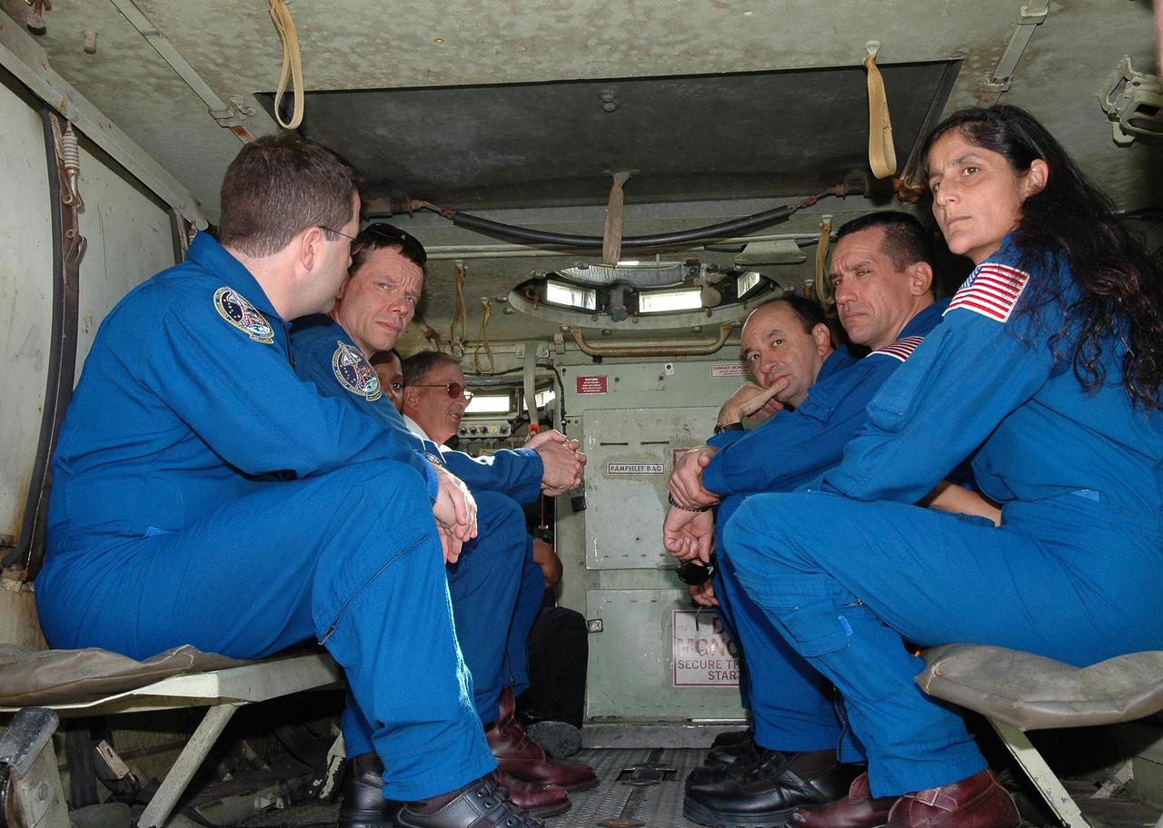 KENNEDY SPACE CENTER, FLA. -- STS-116 crew members wait for a practice ride in the M-113 armored personnel carrier. The mission crew is at KSC for terminal countdown demonstration test (TCDT) activities that are preparation for launch. On the left are Mission Specialists Nicholas Patrick, Christer Fuglesang, Joan Higginbotham and Capt. George Hoggard, who is astronaut rescue team leader. On the right are (left to right) Commander Mark Polansky, Pilot William Oefelein and Mission Specialist Sunita Williams. Not in the picture is Mission Specialist Robert Curbeam. The M-113 could be used to move the crew quickly away from the launch pad in the event of an emergency. The STS-116 mission is No. 20 to the International Space Station and construction flight 12A.1. The mission payload is the SPACEHAB module, the P5 integrated truss structure and other key components. Launch is scheduled for no earlier than Dec. 7. Photo credit: NASA/Kim Shiflett