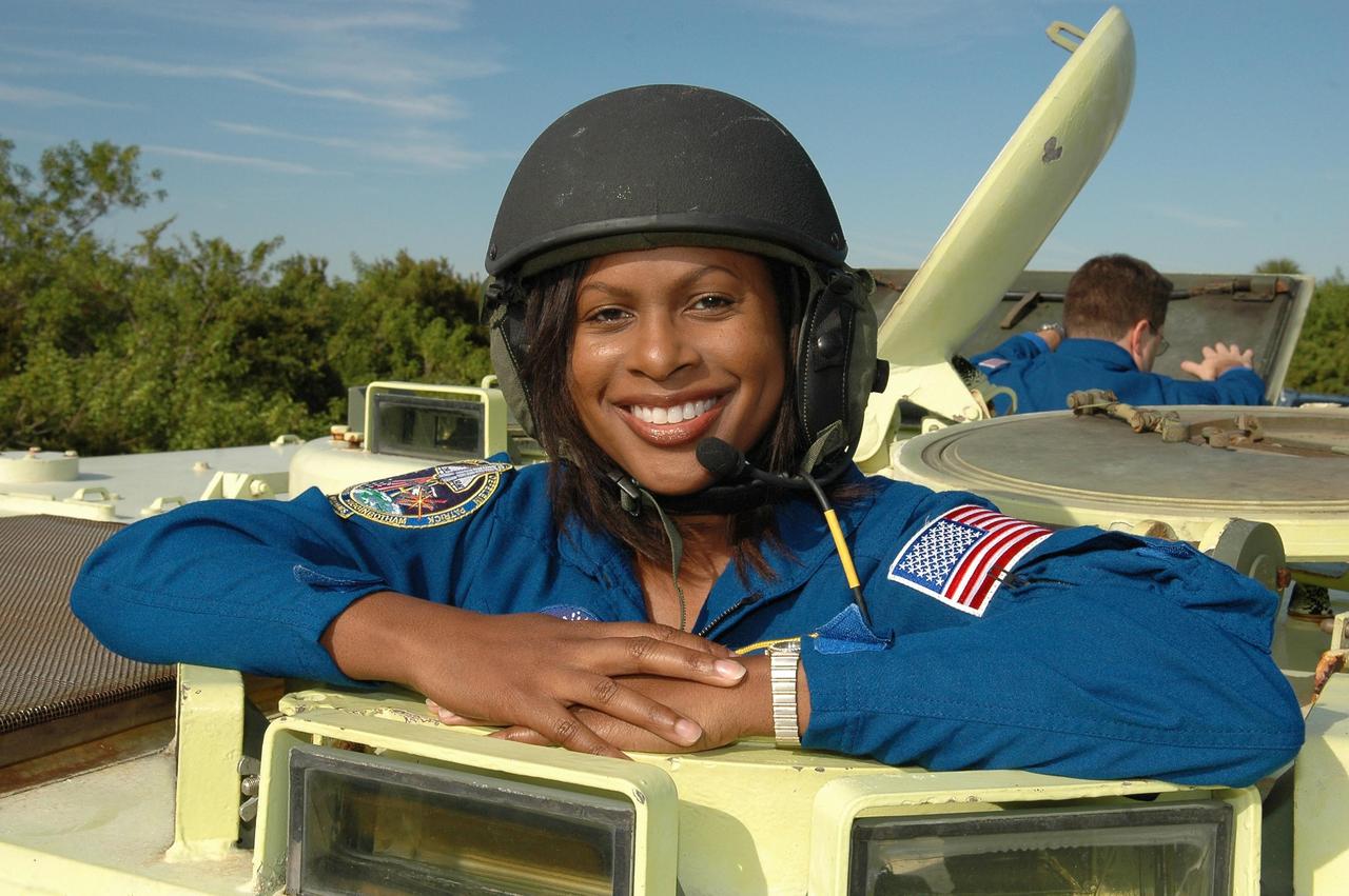 KENNEDY SPACE CENTER, FLA. --  STS-116 Mission Specialist Joan Higginbotham is helmeted and ready to practice driving the M-113 armored personnel carrier.  The mission crew is at KSC for terminal countdown demonstration test (TCDT) activities that are preparation for launch. The M-113 could be used to move the crew quickly away from the launch pad in the event of an emergency. In the background is Mission Specialist Nicholas Patrick.   The STS-116 mission is No. 20 to the International Space Station and construction flight 12A.1.  The mission payload is the SPACEHAB module, the P5 integrated truss structure and other key components. Launch is scheduled for no earlier than Dec. 7.  Photo credit: NASA/Kim Shiflett