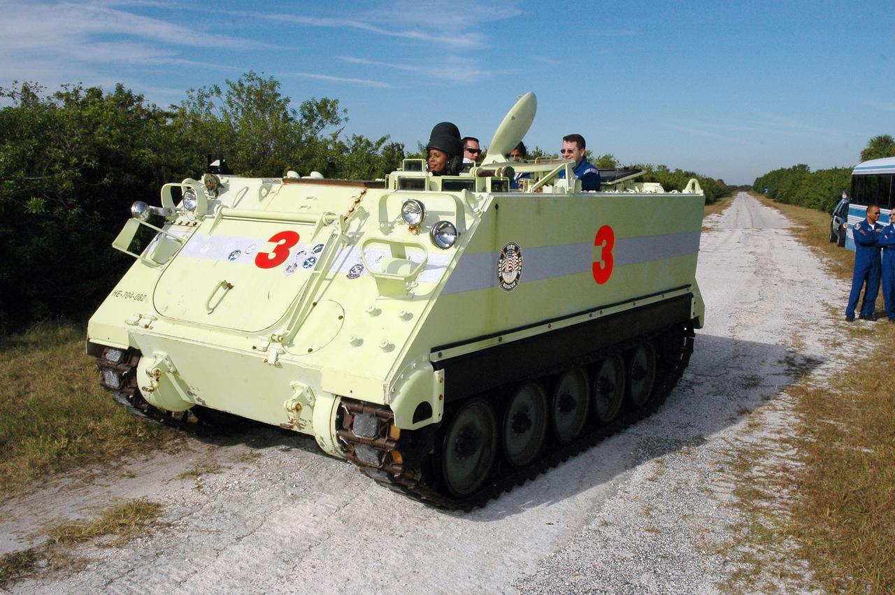 KENNEDY SPACE CENTER, FLA. --   STS-116 Mission Specialist Joan Higginbotham practices driving the M-113 armored personnel carrier.  The mission crew is at KSC for terminal countdown demonstration test (TCDT) activities that are preparation for launch. The M-113 could be used to move the crew quickly away from the launch pad in the event of an emergency. In the background can be seen Pilot William Oefelein and Mission Specialist Nicholas Patrick.  The STS-116 mission is No. 20 to the International Space Station and construction flight 12A.1.  The mission payload is the SPACEHAB module, the P5 integrated truss structure and other key components. Launch is scheduled for no earlier than Dec. 7.  Photo credit: NASA/Kim Shiflett