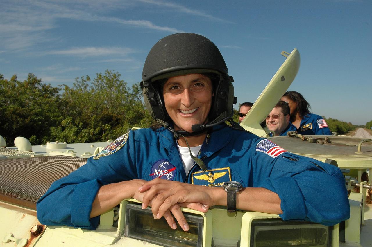KENNEDY SPACE CENTER, FLA. --   STS-116 Mission Specialist Sunita Williams is helmeted and ready to practice driving the M-113 armored personnel carrier.  The mission crew is at KSC for terminal countdown demonstration test (TCDT) activities that are preparation for launch. The M-113 could be used to move the crew quickly away from the launch pad in the event of an emergency. Behind Patrick, at right, are Pilot William Oefelein and Mission Specialists Nicholas Patrick and Joan Higginbotham.  The STS-116 mission is No. 20 to the International Space Station and construction flight 12A.1.  The mission payload is the SPACEHAB module, the P5 integrated truss structure and other key components. Launch is scheduled for no earlier than Dec. 7.  Photo credit: NASA/Kim Shiflett