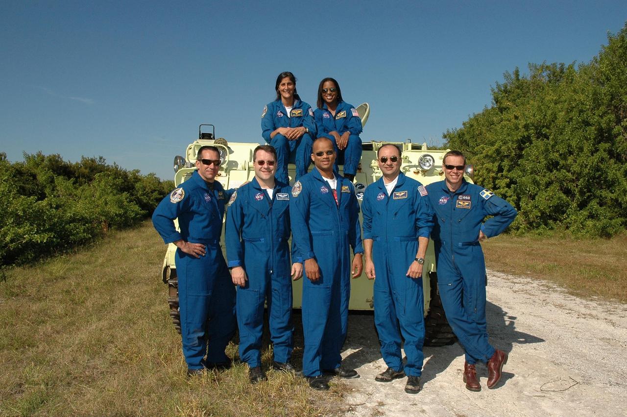 KENNEDY SPACE CENTER, FLA. --  The STS-116 crew gathers for a photo after their successful training on the M-113 armored personnel carrier.  On top are Mission Specialists Sunita Williams (left) and Joan Higginbotham.  In front are (left to right) Pilot William Oefelein, Mission Specialists Nicholas Patrick and Robert Curbeam, Commander Mark Polansky and Mission Specialist Christer Fuglesang, who represents the European Space Agency.  The STS-116 mission is No. 20 to the International Space Station and construction flight 12A.1.  The mission payload is the SPACEHAB module, the P5 integrated truss structure and other key components. Launch is scheduled for no earlier than Dec. 7.  Photo credit: NASA/Kim Shiflett