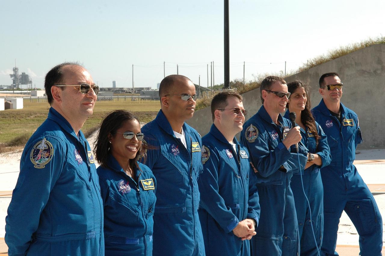 KENNEDY SPACE CENTER, FLA. -- The STS-116 crew pause in their prelaunch activities to talk to the media at Launch Pad 39B. Mission Specialist Christer Fuglesang has the microphone to answer a question. The other crew members are, from left, Commander Mark Polansky, Mission Specialists Joan Higginbotham, Robert Curbeam, Nicholas Patrick, (Fuglesang) and Sunita Williams, and Pilot William Oefelein. Fuglesang represents the European Space Agency. The mission crew is at KSC for the TCDT, which includes a simulated launch countdown. The STS-116 mission is No. 20 to the International Space Station and construction flight 12A.1. The mission payload is the SPACEHAB module, the P5 integrated truss structure and other key components. Launch is scheduled for no earlier than Dec. 7. Photo credit: NASA/Kim Shiflett