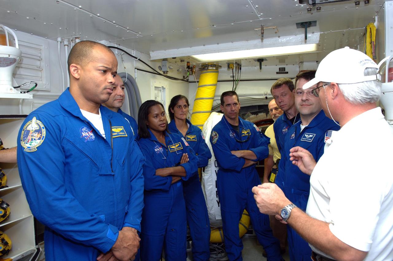 KENNEDY SPACE CENTER, FLA. --  In the White Room on Launch Pad 39B, the STS-116 crew members are told what to expect on launch day as they enter Space Shuttle Discovery from the area.  From left are Mission Specialist Robert Curbeam, Commander Mark Polansky, Mission Specialists Joan Higginbotham and Sunita Williams, Pilot William Oefelein, and Mission Specialists Christer Fuglesang and Nicholas Patrick.  Fuglesang represents the European Space Agency. The mission crew is at KSC for the TCDT, which includes a simulated launch countdown.   The STS-116 mission is No. 20 to the International Space Station and construction flight 12A.1.  The mission payload is the SPACEHAB module, the P5 integrated truss structure and other key components. Launch is scheduled for no earlier than Dec. 7.  Photo credit: NASA/Kim Shiflett