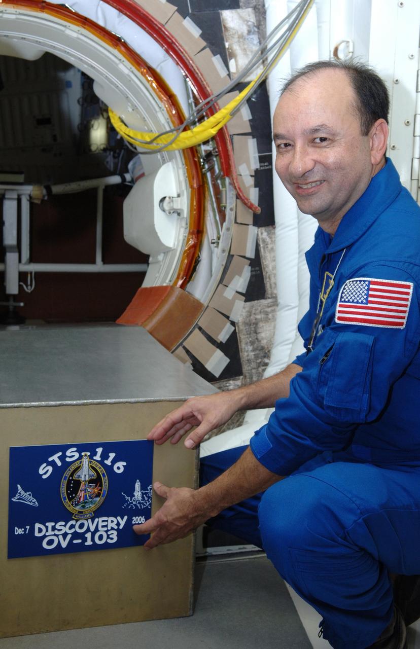 KENNEDY SPACE CENTER, FLA. --  In the White Room on Launch Pad 39B, STS-116 Commander Mark Polansky places the mission placard at the hatch opening.  The White Room is the point of entry into Space Shuttle Discovery for the crew.  Other crew members are Pilot William Oefelein and Mission Specialists Joan Higginbotham, Sunita Williams, Nicholas Patrick, Robert Curbeam and Christer Fuglesang, who represents the European Space Agency.  The mission crew is at KSC for the TCDT, which includes a simulated launch countdown.   The STS-116 mission is No. 20 to the International Space Station and construction flight 12A.1.  The mission payload is the SPACEHAB module, the P5 integrated truss structure and other key components. Launch is scheduled for no earlier than Dec. 7.  Photo credit: NASA/Kim Shiflett