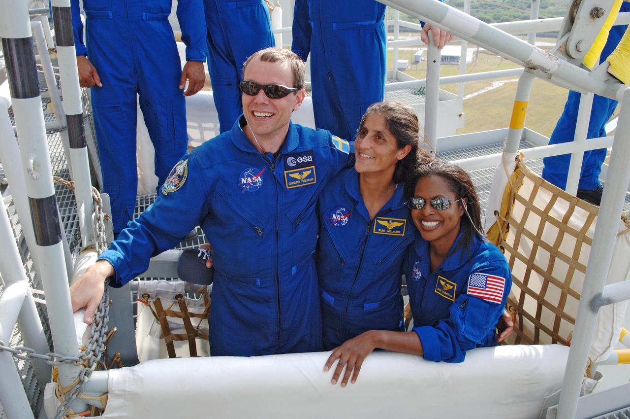 KENNEDY SPACE CENTER, FLA. --   On the fixed service structure on Launch Pad 39B, STS-116 Mission Specialists Christer Fuglesang, Sunita Williams and Joan Higginbotham happily pose in a slidewire basket used for emergency egress from the orbiter.  The STS-116 mission is No. 20 to the International Space Station and construction flight 12A.1.  The mission payload is the SPACEHAB module, the P5 integrated truss structure and other key components. Launch is scheduled for no earlier than Dec. 7.  Photo credit: NASA/Kim Shiflett