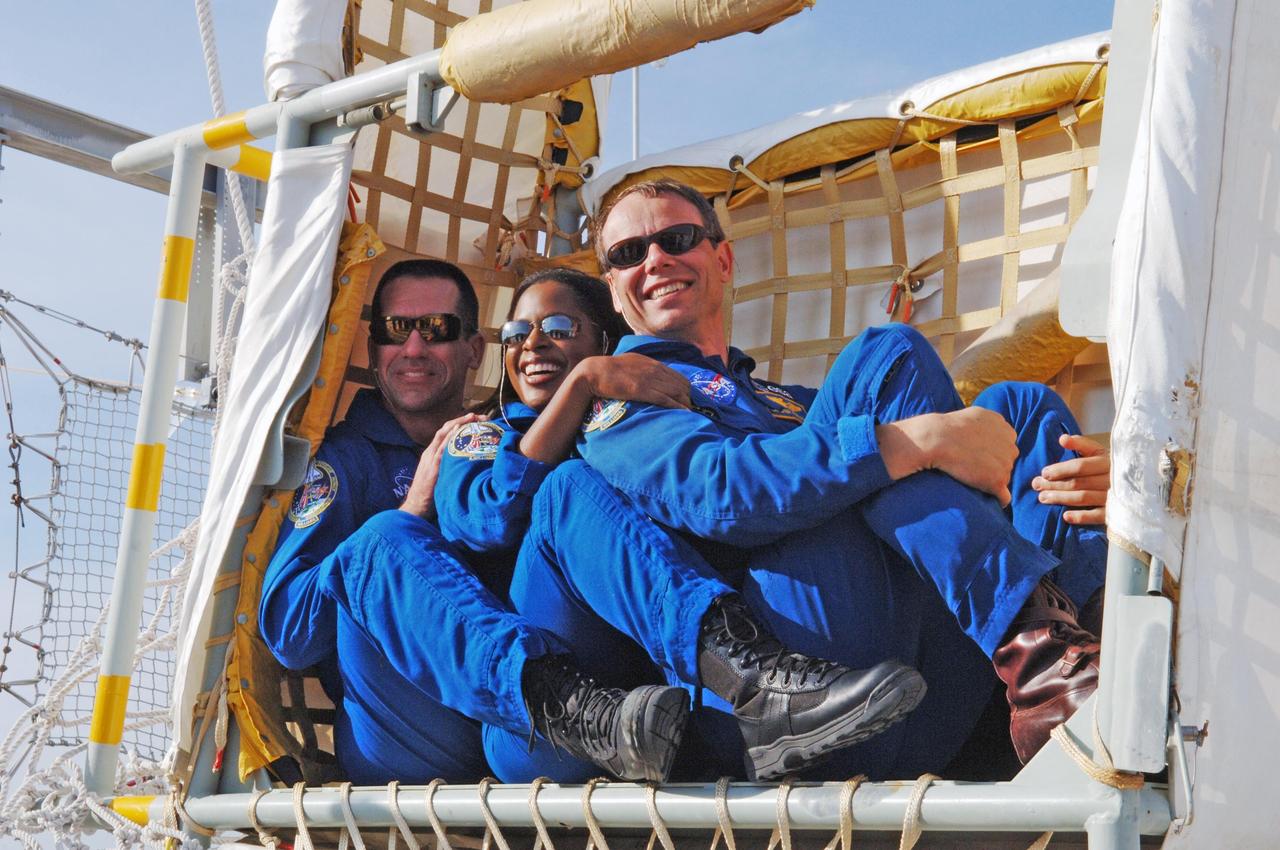 KENNEDY SPACE CENTER, FLA. -- At the slidewire basket landing area at Launch Pad 39B, STS-116 crew members sit in one of the baskets used for emergency egress from the orbiter. From left are Pilot William Oefelein and Mission Specialists Joan Higginbotham and Christer Fuglesang, who represents the European Space Agency. The STS-116 mission is No. 20 to the International Space Station and construction flight 12A.1.  The mission payload is the SPACEHAB module, the P5 integrated truss structure and other key components. Launch is scheduled for no earlier than Dec. 7.  Photo credit: NASA/Kim Shiflett