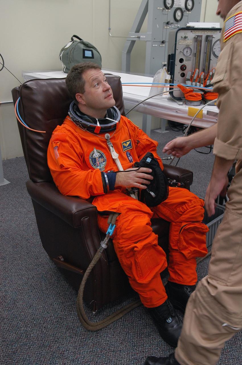 KENNEDY SPACE CENTER, FLA. -- The STS-116 mission crew practices for launch with a simulation of activities, from crew breakfast and suit-up to countdown in the orbiter. In this photo Mission Specialist Nicholas Patrick dons his launch suit before heading to Launch Pad 39B. The STS-116 mission is No. 20 to the International Space Station and construction flight 12A.1. The mission payload is the SPACEHAB module, the P5 integrated truss structure and other key components. Launch is scheduled for no earlier than Dec. 7. Photo credit: NASA/Kim Shiflett