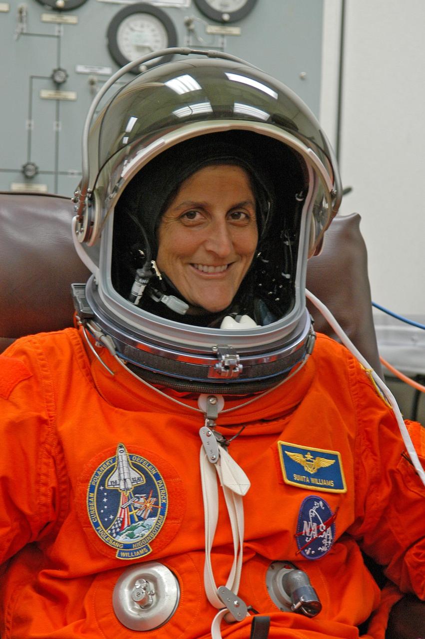 KENNEDY SPACE CENTER, FLA. -- The STS-116 mission crew practices for launch with a simulation of activities, from crew breakfast and suit-up to countdown in the orbiter. In this photo Mission Specialist Sunita Williams puts on her helmet before heading to Launch Pad 39B. The STS-116 mission is No. 20 to the International Space Station and construction flight 12A.1. The mission payload is the SPACEHAB module, the P5 integrated truss structure and other key components. Launch is scheduled for no earlier than Dec. 7. Photo credit: NASA/Kim Shiflett