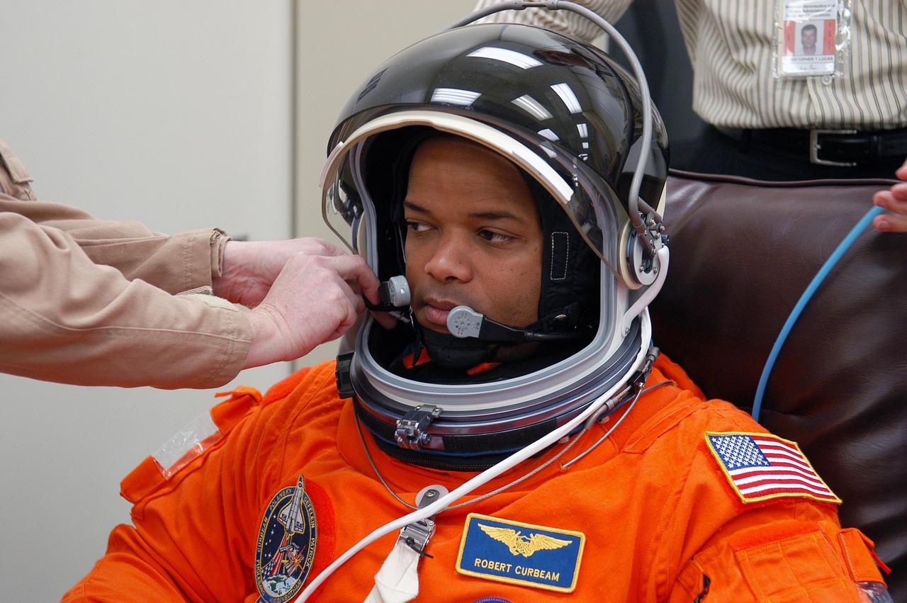 KENNEDY SPACE CENTER, FLA. -- The STS-116 mission crew practices for launch with a simulation of activities, from crew breakfast and suit-up to countdown in the orbiter. In this photo Mission Specialist Robert Curbeam has his helmet adjusted before heading to Launch Pad 39B. The STS-116 mission is No. 20 to the International Space Station and construction flight 12A.1. The mission payload is the SPACEHAB module, the P5 integrated truss structure and other key components. Launch is scheduled for no earlier than Dec. 7. Photo credit: NASA/Kim Shiflett