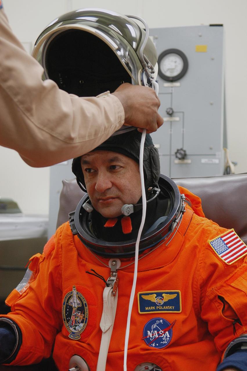 KENNEDY SPACE CENTER, FLA. --  The STS-116 mission crew practices for launch with a simulation of activities, from crew breakfast and suit-up to countdown in the orbiter.  In this photo Commander Mark Polansky is helped with his helmet before heading to Launch Pad 39B.  The STS-116 mission is No. 20 to the International Space Station and construction flight 12A.1.  The mission payload is the SPACEHAB module, the P5 integrated truss structure and other key components. Launch is scheduled for no earlier than Dec. 7. Photo credit: NASA/Kim Shiflett