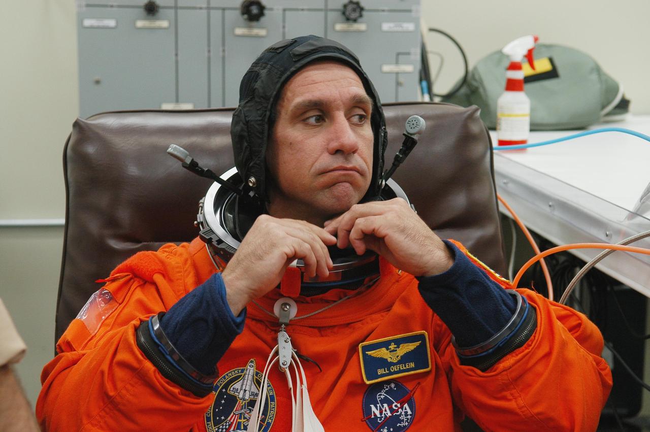 KENNEDY SPACE CENTER, FLA. -- The STS-116 mission crew practices for launch with a simulation of activities, from crew breakfast and suit-up to countdown in the orbiter. In this photo Pilot William Oefelein fixes the neck of his launch suit before heading to Launch Pad 39B. The STS-116 mission is No. 20 to the International Space Station and construction flight 12A.1. The mission payload is the SPACEHAB module, the P5 integrated truss structure and other key components. Launch is scheduled for no earlier than Dec. 7. Photo credit: NASA/Kim Shiflett