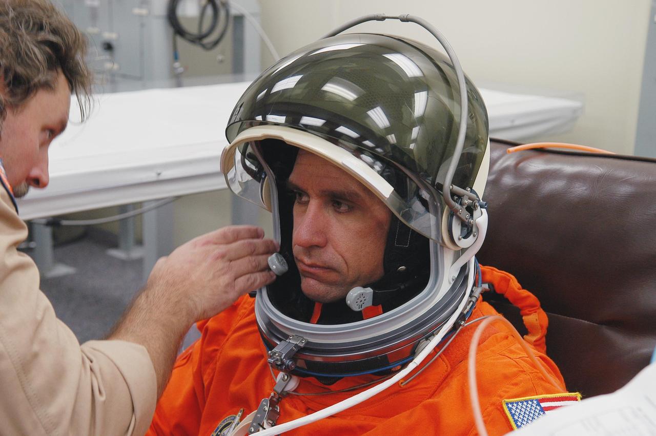 KENNEDY SPACE CENTER, FLA. -- The STS-116 mission crew practices for launch with a simulation of activities, from crew breakfast and suit-up to countdown in the orbiter. In this photo Pilot William Oefelein has his helmet adjusted before heading to Launch Pad 39B. The STS-116 mission is No. 20 to the International Space Station and construction flight 12A.1. The mission payload is the SPACEHAB module, the P5 integrated truss structure and other key components. Launch is scheduled for no earlier than Dec. 7. Photo credit: NASA/Kim Shiflett
