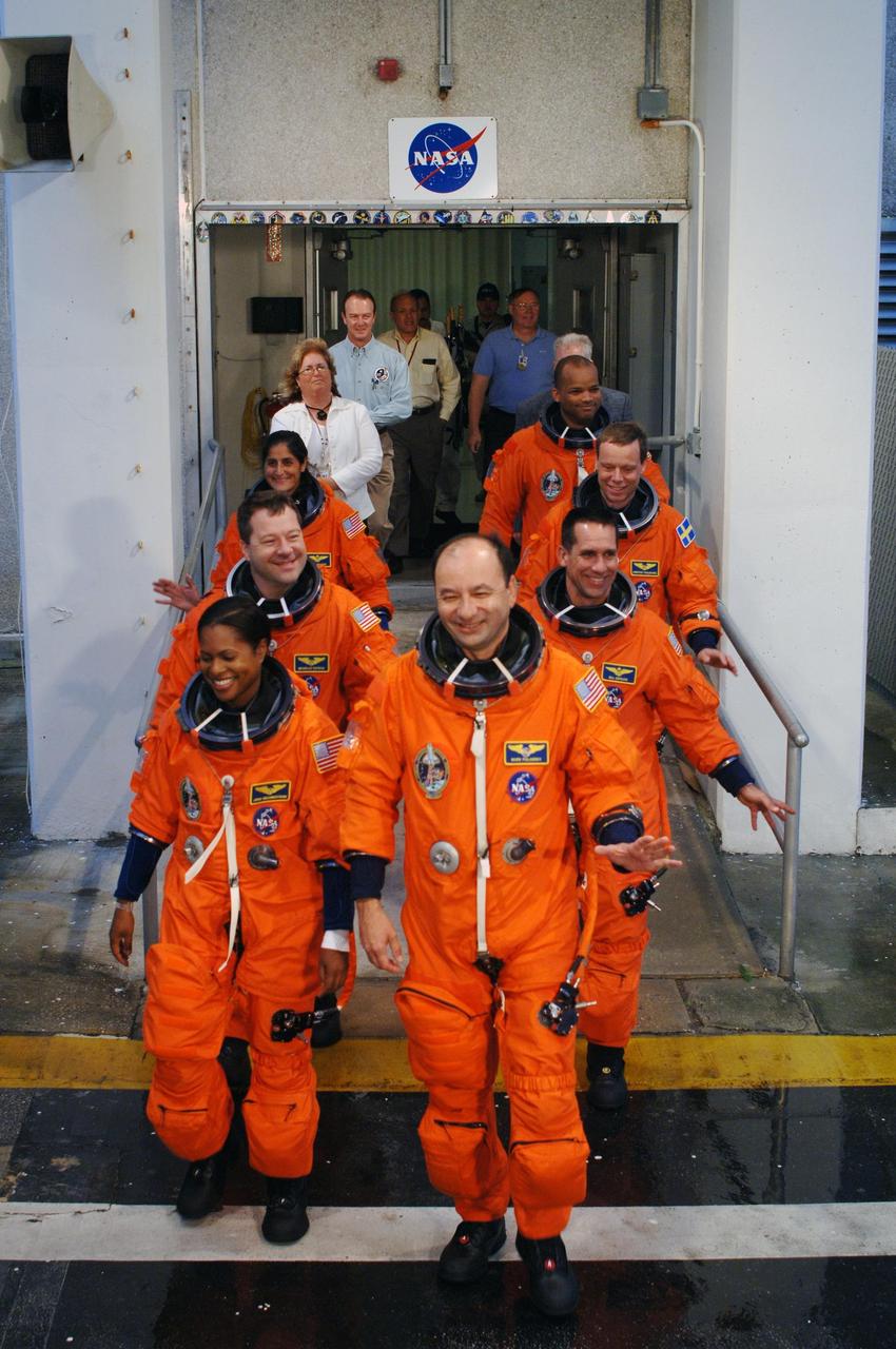 KENNEDY SPACE CENTER, FLA. -- The STS-116 crew walks out of the Operations and Checkout Building on their way to Launch Pad 39B during the terminal countdown demonstration test. The crew is practicing for launch with a simulation of activities, from crew breakfast and suit-up to countdown in the orbiter. Leading the way are Commander Mark Polansky (right) and Mission Specialist Joan Higginbotham (left). Behind them are (left and right) Mission Specialist Nicholas Patrick and Pilot William Oefelein; Mission Specialists Sunita Williams and Christer Fuglesang, who represents the European Space Agency; and Mission Specialist Robert Curbeam (right). The STS-116 mission is No. 20 to the International Space Station and construction flight 12A.1. The mission payload is the SPACEHAB module, the P5 integrated truss structure and other key components. Launch is scheduled for no earlier than Dec. 7. Photo credit: NASA/Kim Shiflett