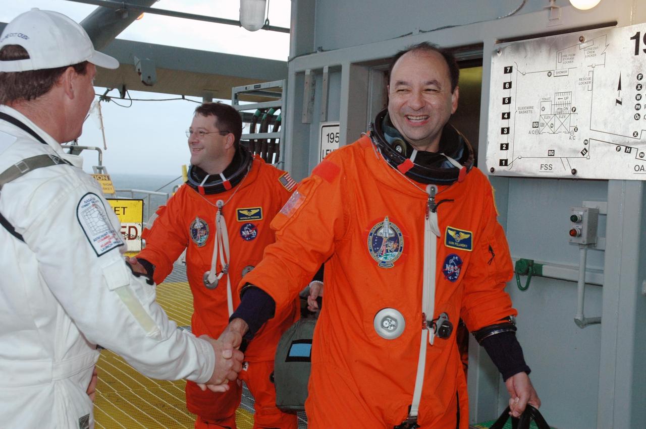 KENNEDY SPACE CENTER, FLA. -- On their way to the white room on Launch Pad 39B to enter Space Shuttle Discovery, Commander Mark Polansky (right) and Mission Specialist Nicholas Patrick are greeted by the closeout crew. The STS-116 mission crew practices for launch with a simulation of activities, from suit-up to countdown in the orbiter. The STS-116 mission is No. 20 to the International Space Station and construction flight 12A.1. The mission payload is the SPACEHAB module, the P5 integrated truss structure and other key components. Launch is scheduled for no earlier than Dec. 7. Photo credit: NASA/Amanda Diller