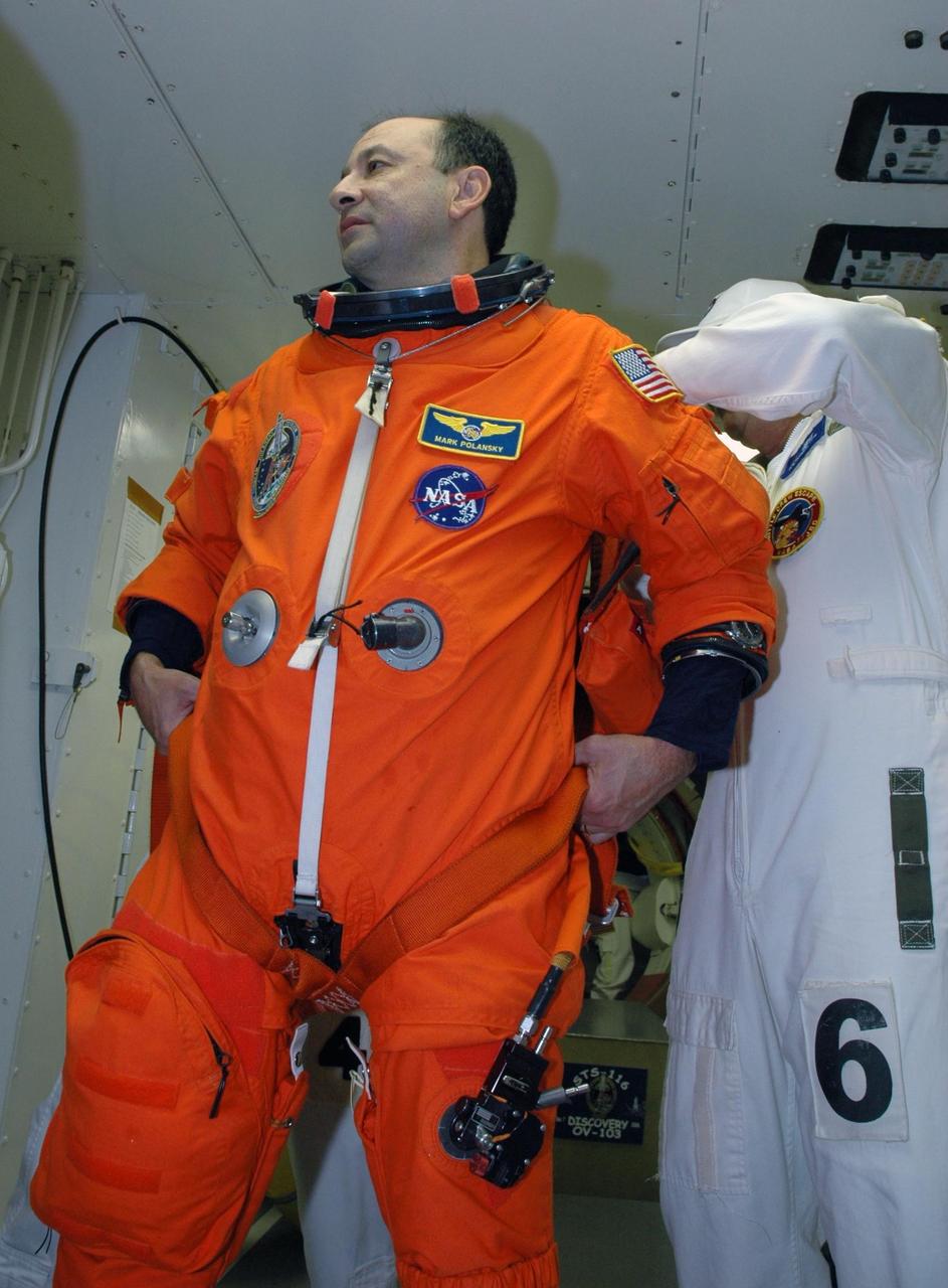KENNEDY SPACE CENTER, FLA. -- In the white room on Launch Pad 39B, STS-116 Commander Mark Polansky is helped with his gear before entering Space Shuttle Discovery. The STS-116 mission is No. 20 to the International Space Station and construction flight 12A.1. The mission payload is the SPACEHAB module, the P5 integrated truss structure and other key components. Launch is scheduled for no earlier than Dec. 7. Photo credit: NASA/Amanda Diller