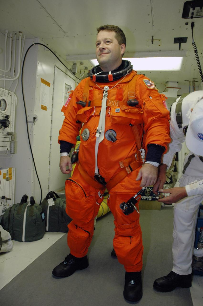 KENNEDY SPACE CENTER, FLA. -- In the white room on Launch Pad 39B, STS-116 Mission Specialist Nicholas Patrick is helped with his gear before entering Space Shuttle Discovery. The mission crew is taking part in a simulated launch countdown, part of the terminal countdown demonstration test that includes prelaunch preparations. The STS-116 mission is No. 20 to the International Space Station and construction flight 12A.1. The mission payload is the SPACEHAB module, the P5 integrated truss structure and other key components. Launch is scheduled for no earlier than Dec. 7. Photo credit: NASA/Amanda Diller