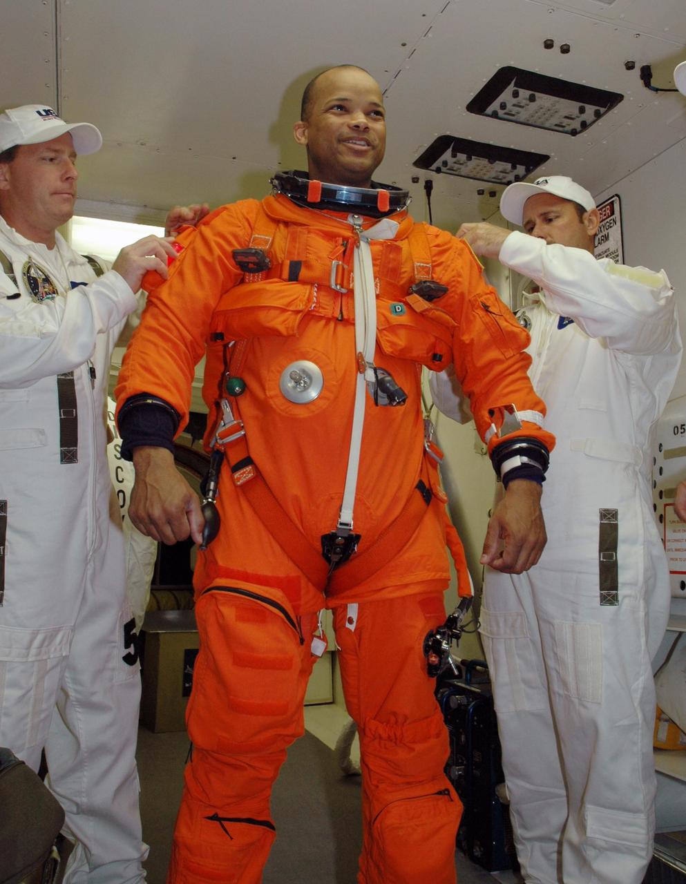 KENNEDY SPACE CENTER, FLA. -- In the white room on Launch Pad 39B, STS-116 Mission Specialist Robert Curbeam is helped with his gear before entering Space Shuttle Discovery. The mission crew is taking part in a simulated launch countdown, part of the terminal countdown demonstration test that includes prelaunch preparations. The STS-116 mission is No. 20 to the International Space Station and construction flight 12A.1. The mission payload is the SPACEHAB module, the P5 integrated truss structure and other key components. Launch is scheduled for no earlier than Dec. 7. Photo credit: NASA/Amanda Diller